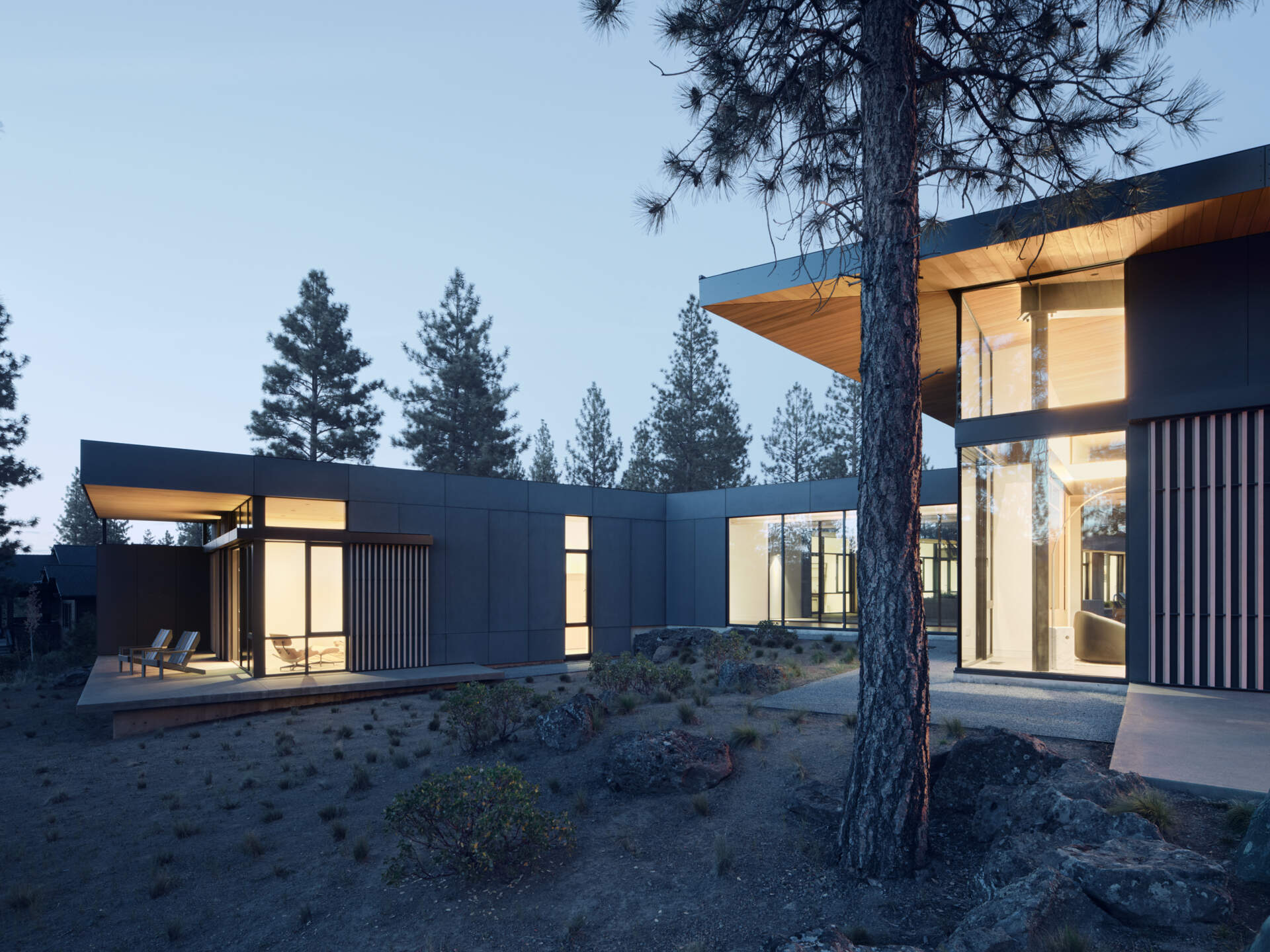 This modern Oregon home combines concrete, black steel, warm wood, and dramatic rooflines for a bold exterior that feels perfectly suited to the forest landscape.