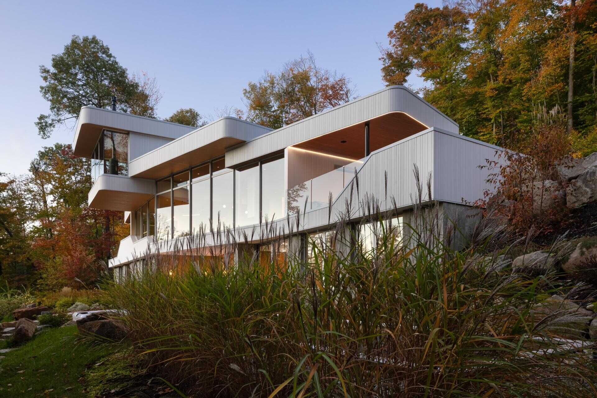 Layered white volumes, dramatic cantilevers, and retro-futuristic forms give this Québec mountain home a striking architectural identity above Lake Xavier.
