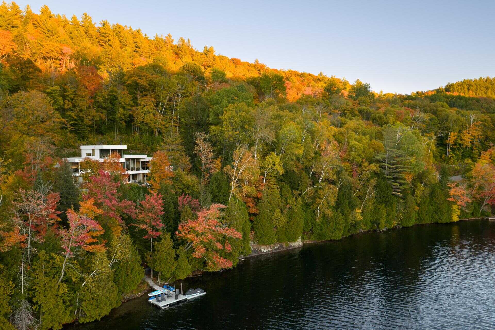 Layered white volumes, dramatic cantilevers, and retro-futuristic forms give this Québec mountain home a striking architectural identity above Lake Xavier.