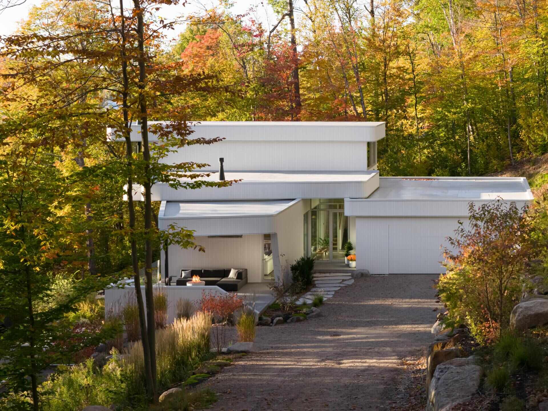 Layered white volumes, dramatic cantilevers, and retro-futuristic forms give this Québec mountain home a striking architectural identity above Lake Xavier.