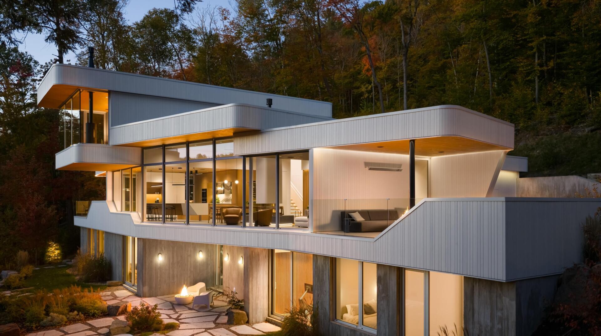 Layered white volumes, dramatic cantilevers, and retro-futuristic forms give this Québec mountain home a striking architectural identity above Lake Xavier.