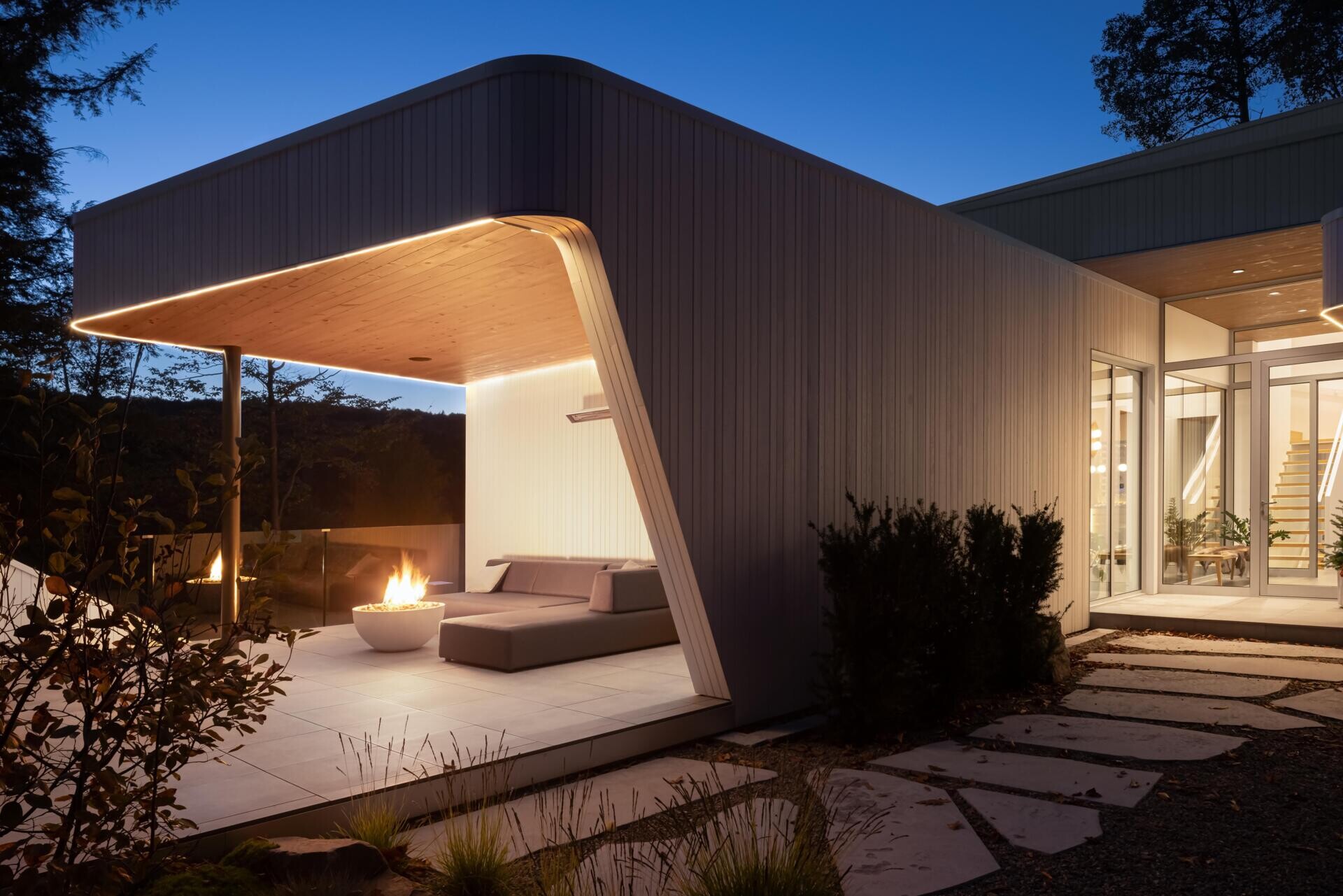 Layered white volumes, dramatic cantilevers, and retro-futuristic forms give this Québec mountain home a striking architectural identity above Lake Xavier.