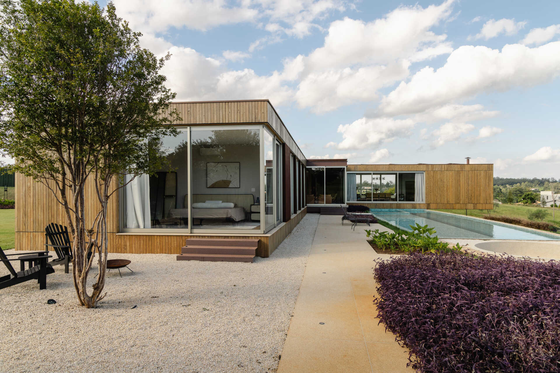 Built into a raised stone platform, the swimming pool terrace at Casa Themis combines panoramic countryside views with modern outdoor living and warm natural materials.