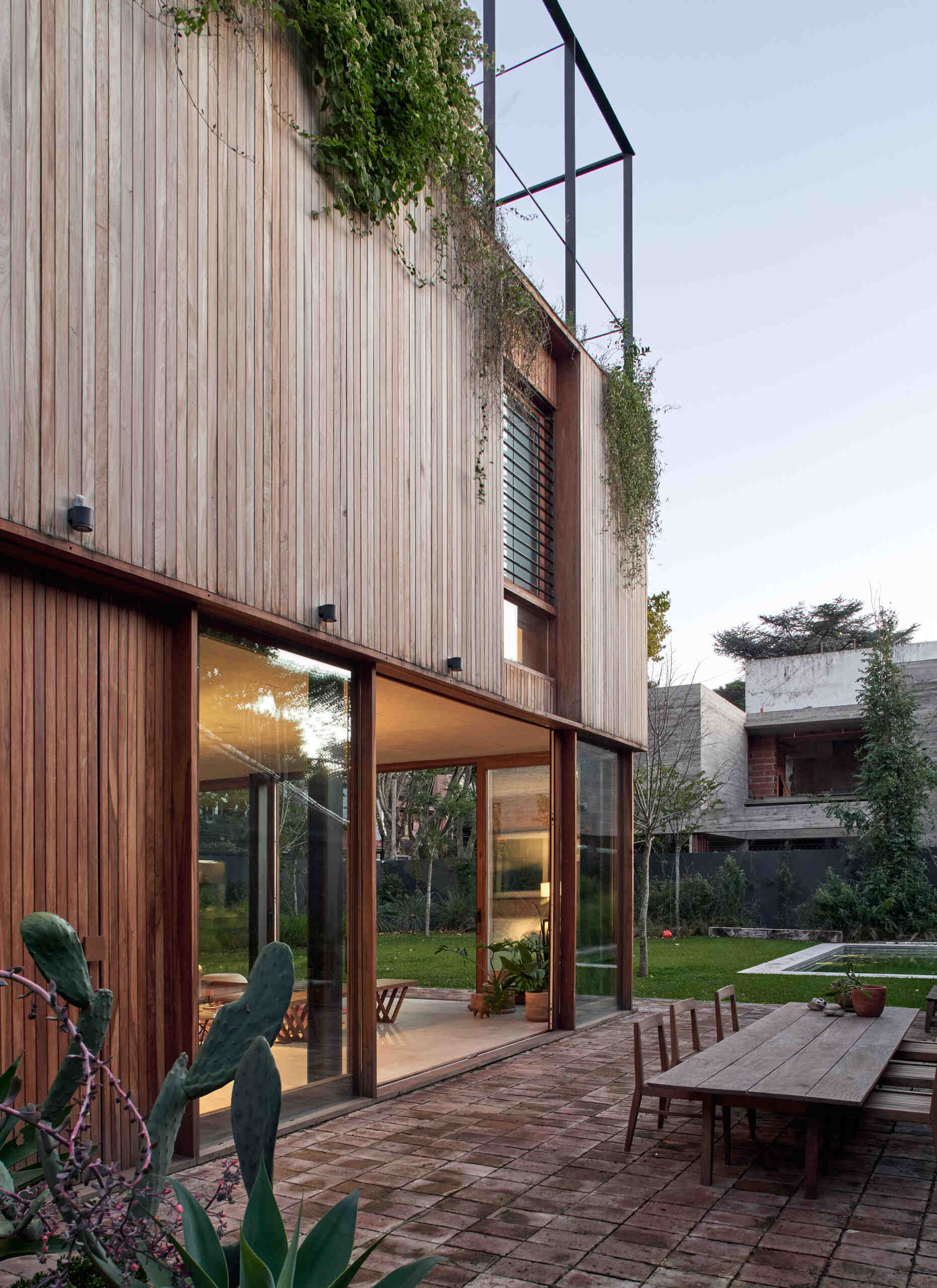 An open living and dining area flows straight into a brick patio, with sliding glass doors creating a seamless indoor-outdoor space.