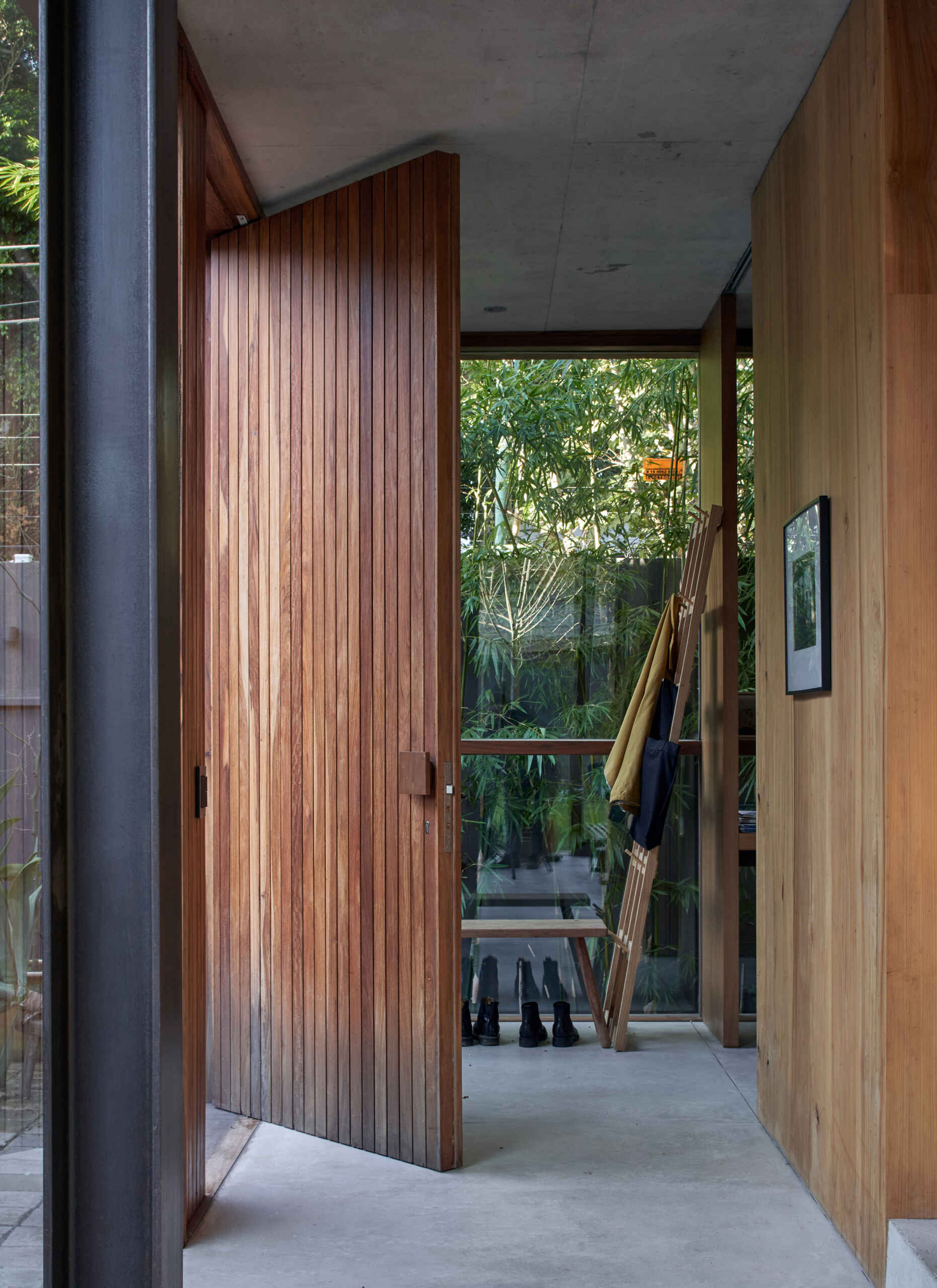 A full-height wood front door adds warmth and scale, creating a welcoming entry behind the brick facade.