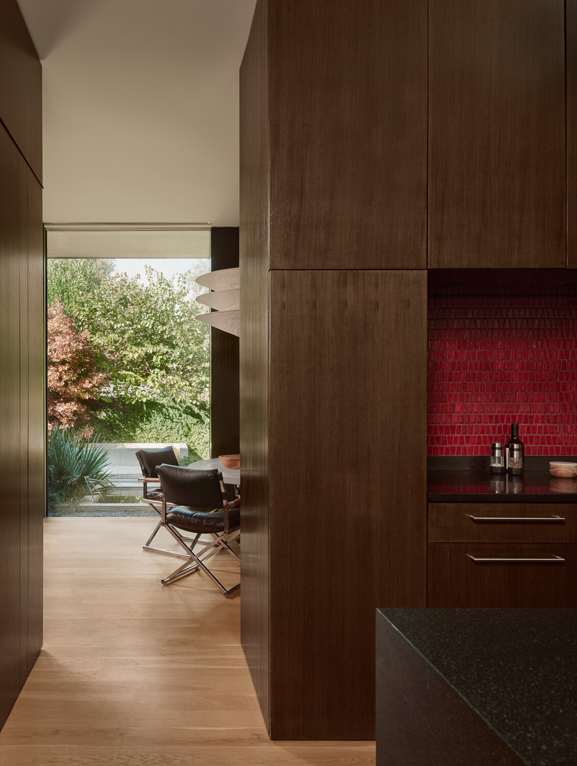 Discover a beautifully crafted kitchen featuring custom cabinetry, honed black granite, white oak flooring, and seamless connections to the surrounding living spaces and gardens.