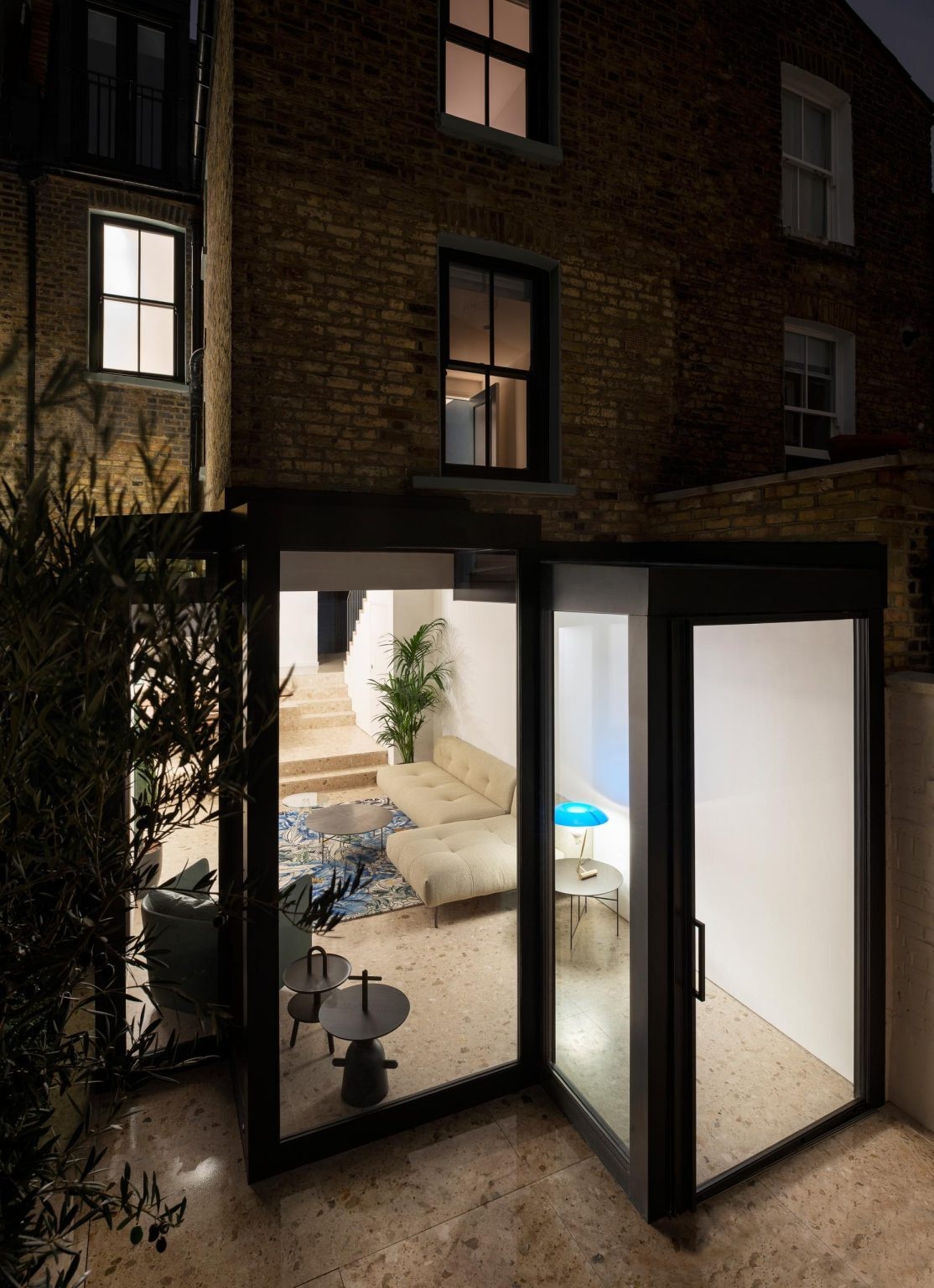 A Victorian terraced house in London transformed with cubist glass volumes, black steel framing, and dramatic geometric forms by Bureau de Change Architects.