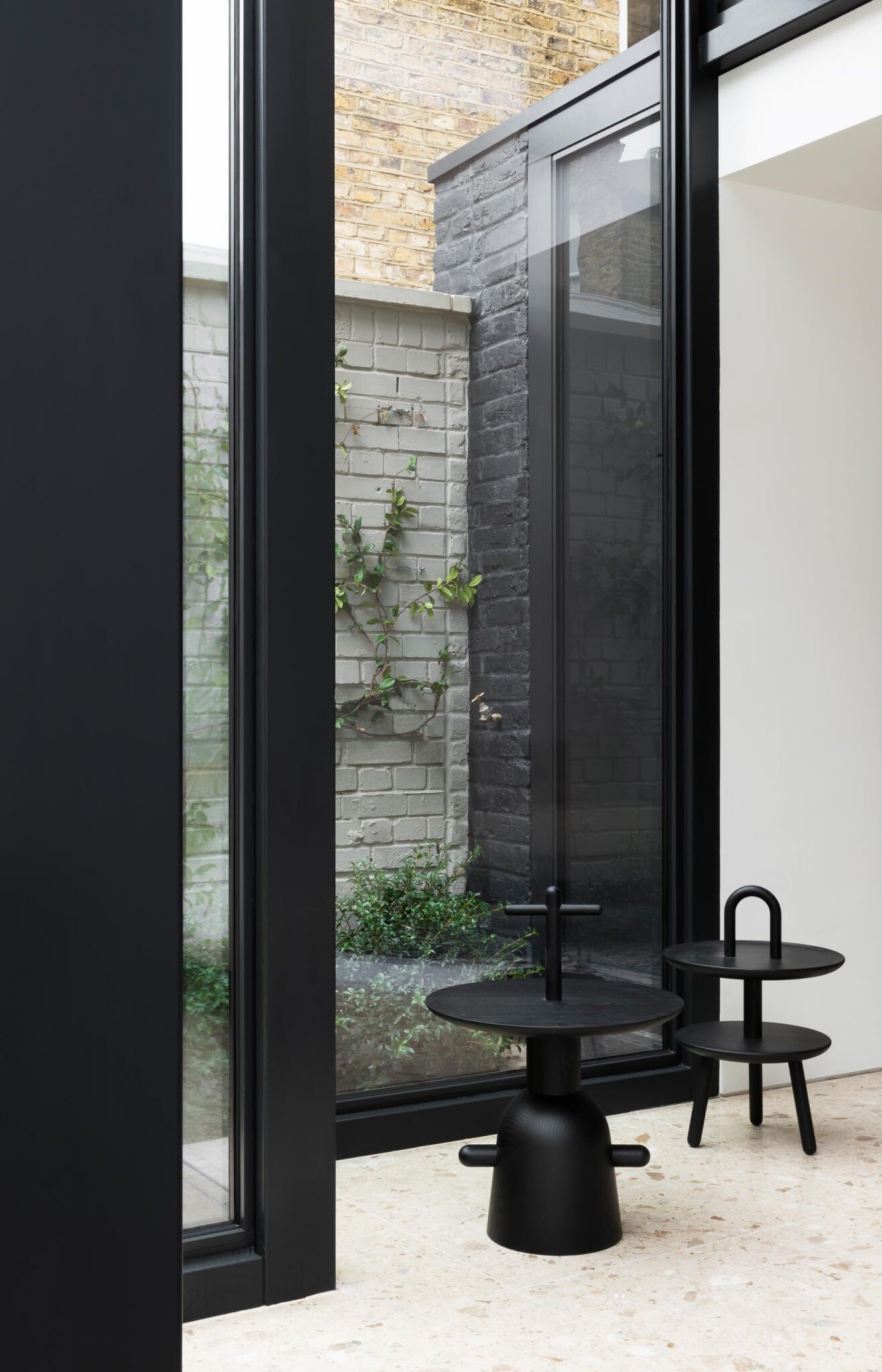 A Victorian terraced house in London transformed with cubist glass volumes, black steel framing, and dramatic geometric forms by Bureau de Change Architects.