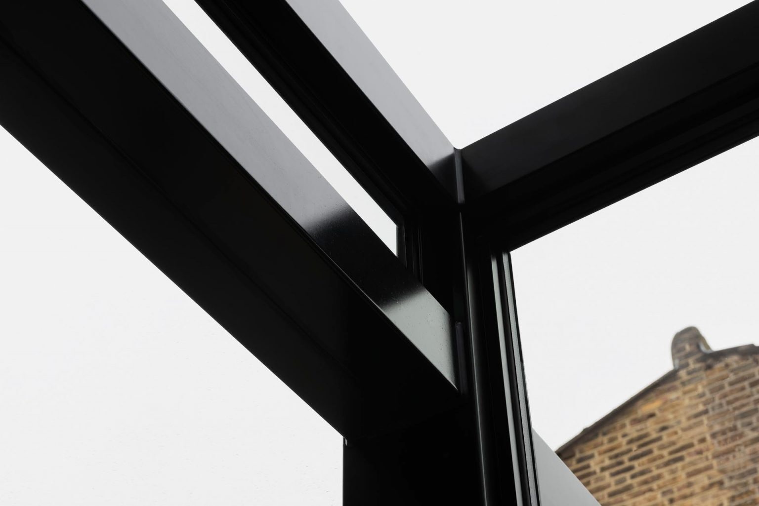 A Victorian terraced house in London transformed with cubist glass volumes, black steel framing, and dramatic geometric forms by Bureau de Change Architects.
