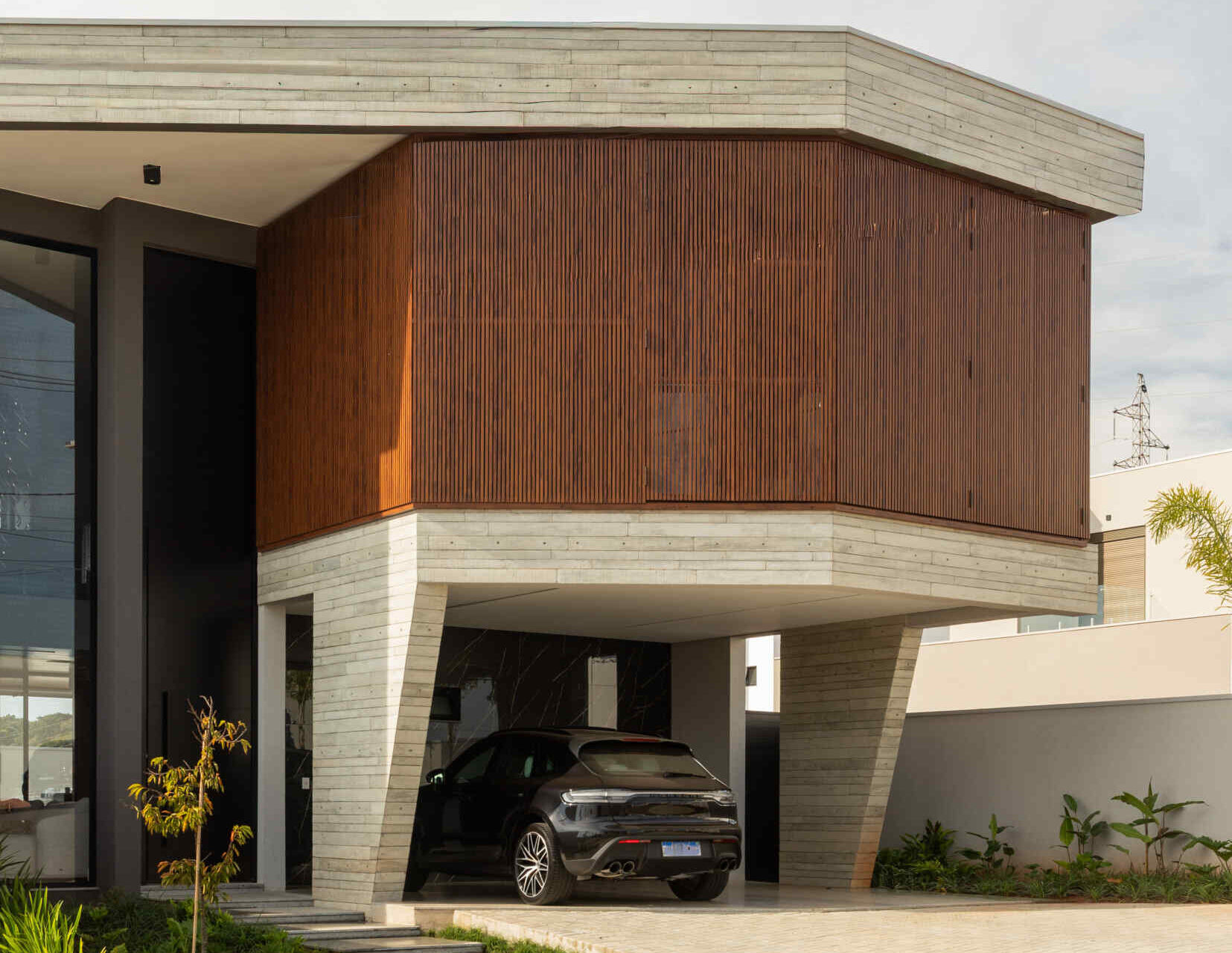Casa R|L by Casalli Arquitetura in Pouso Alegre, Brazil, features sculptural concrete forms, inclined pillars, and warm minimalist interiors shaped around an irregular site.