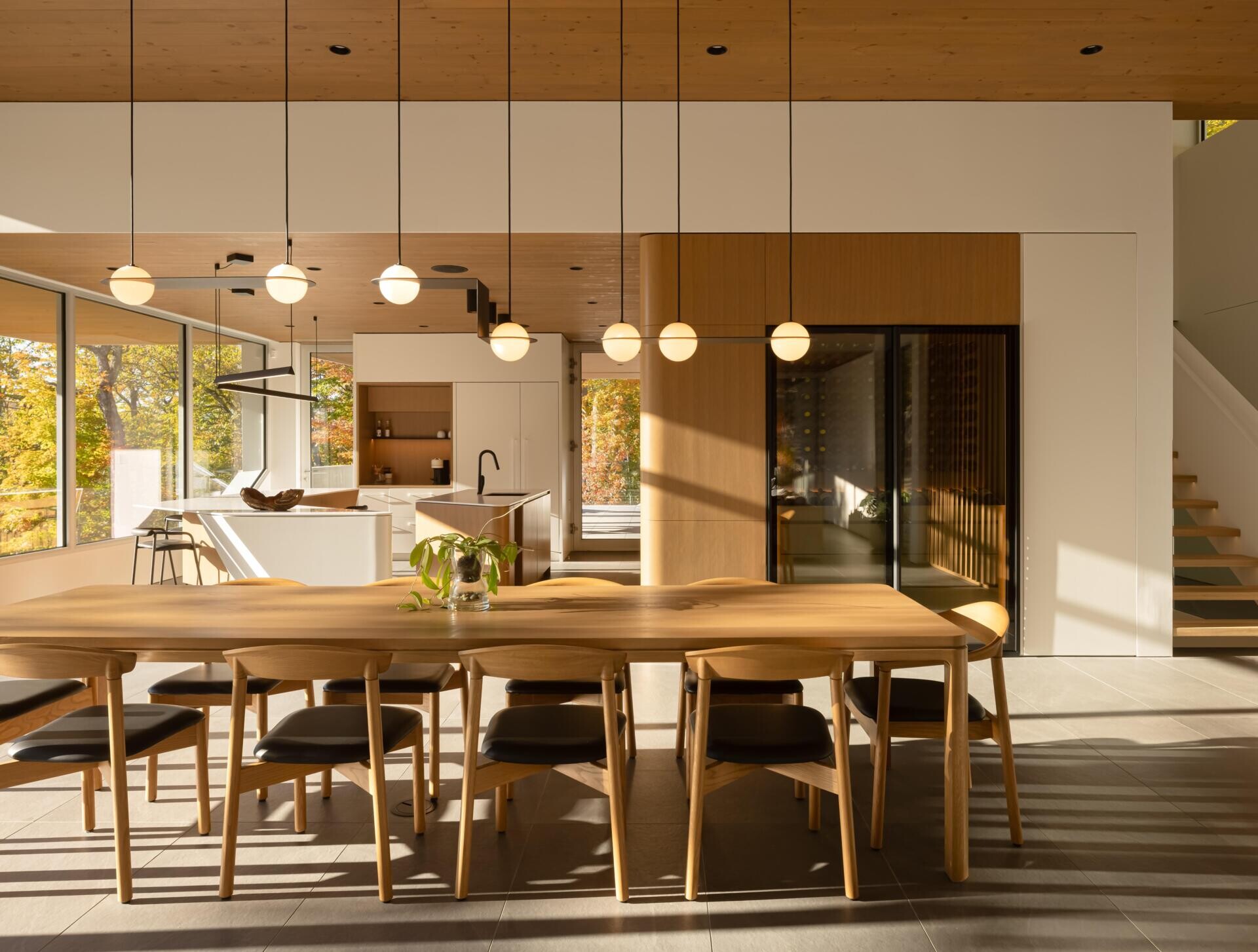 A spacious dining area with panoramic lake views creates the perfect setting for gatherings inside this contemporary Laurentians home.