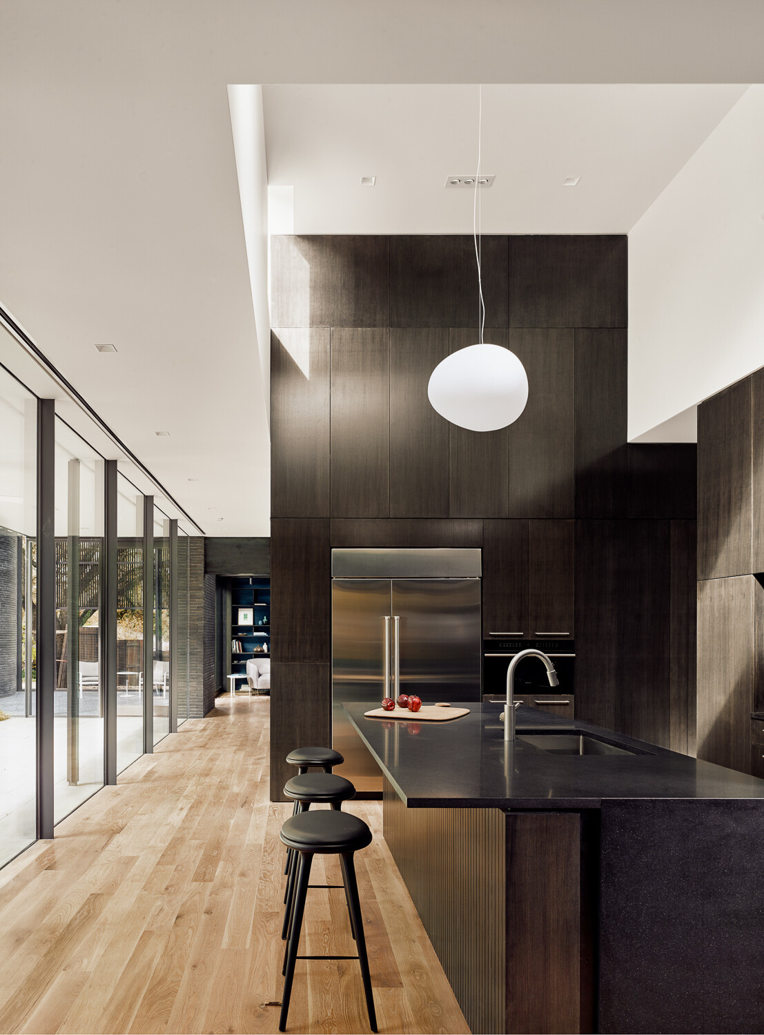 Discover a beautifully crafted kitchen featuring custom cabinetry, honed black granite, white oak flooring, and seamless connections to the surrounding living spaces and gardens.