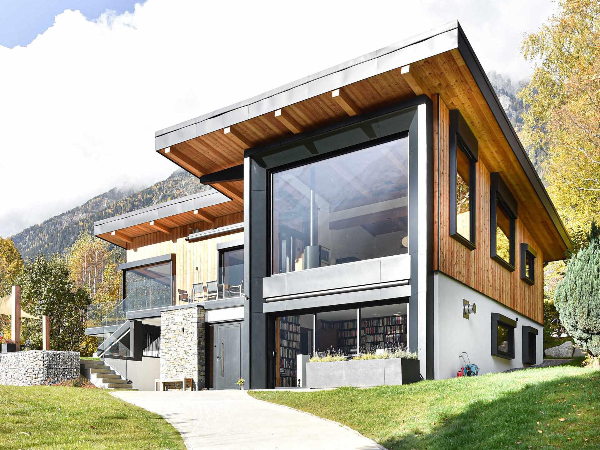 This Chamonix renovation features a massive black framed picture window that perfectly captures mountain views while flooding the home with natural light.