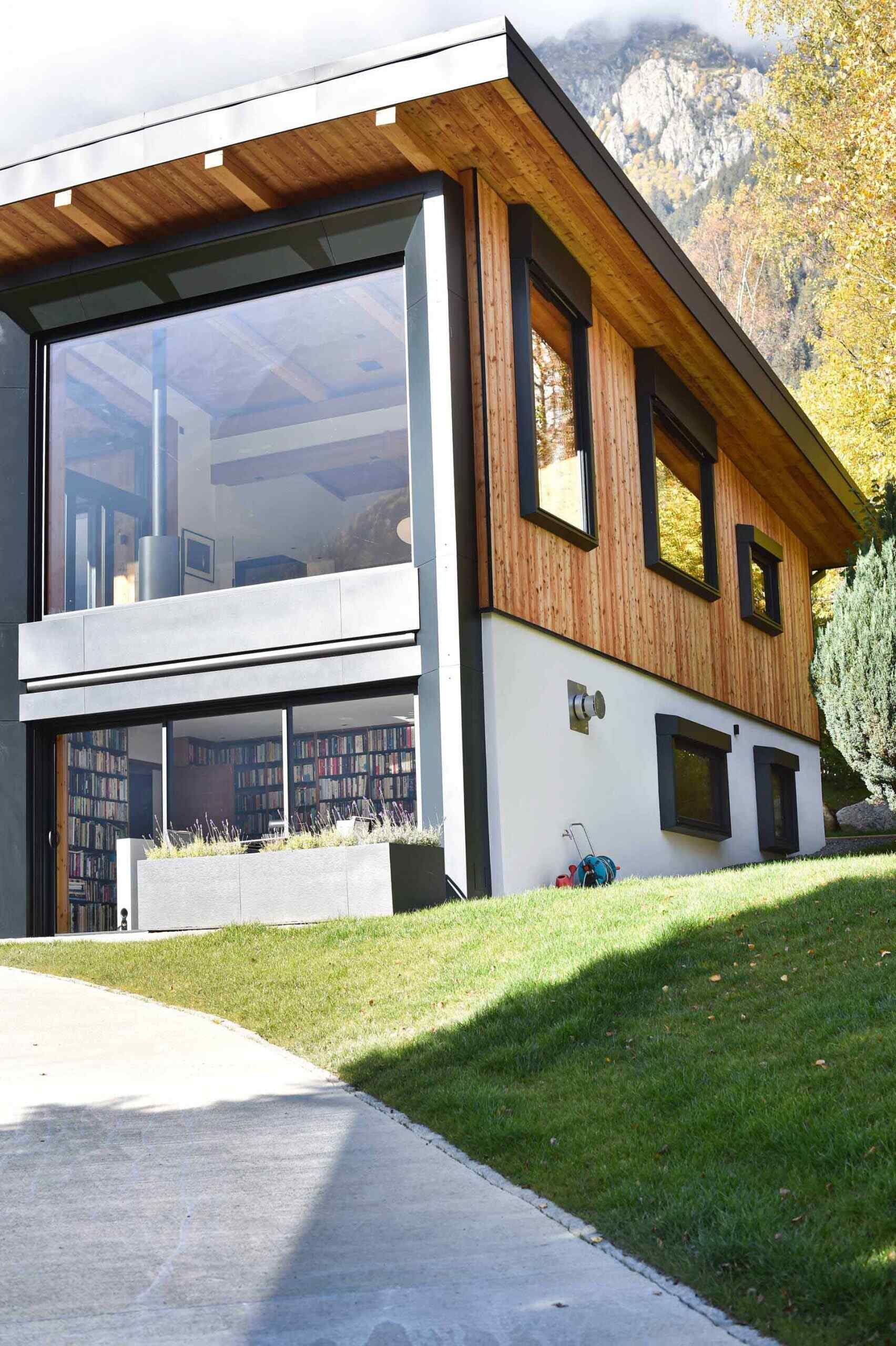 This Chamonix renovation features a massive black framed picture window that perfectly captures mountain views while flooding the home with natural light.