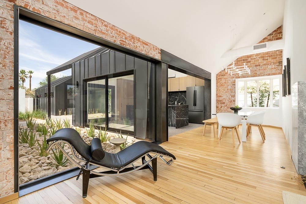 Vaulted ceilings, exposed brick walls, original wood floors, and warm modern furnishings bring new life to this remodeled historic Phoenix home.