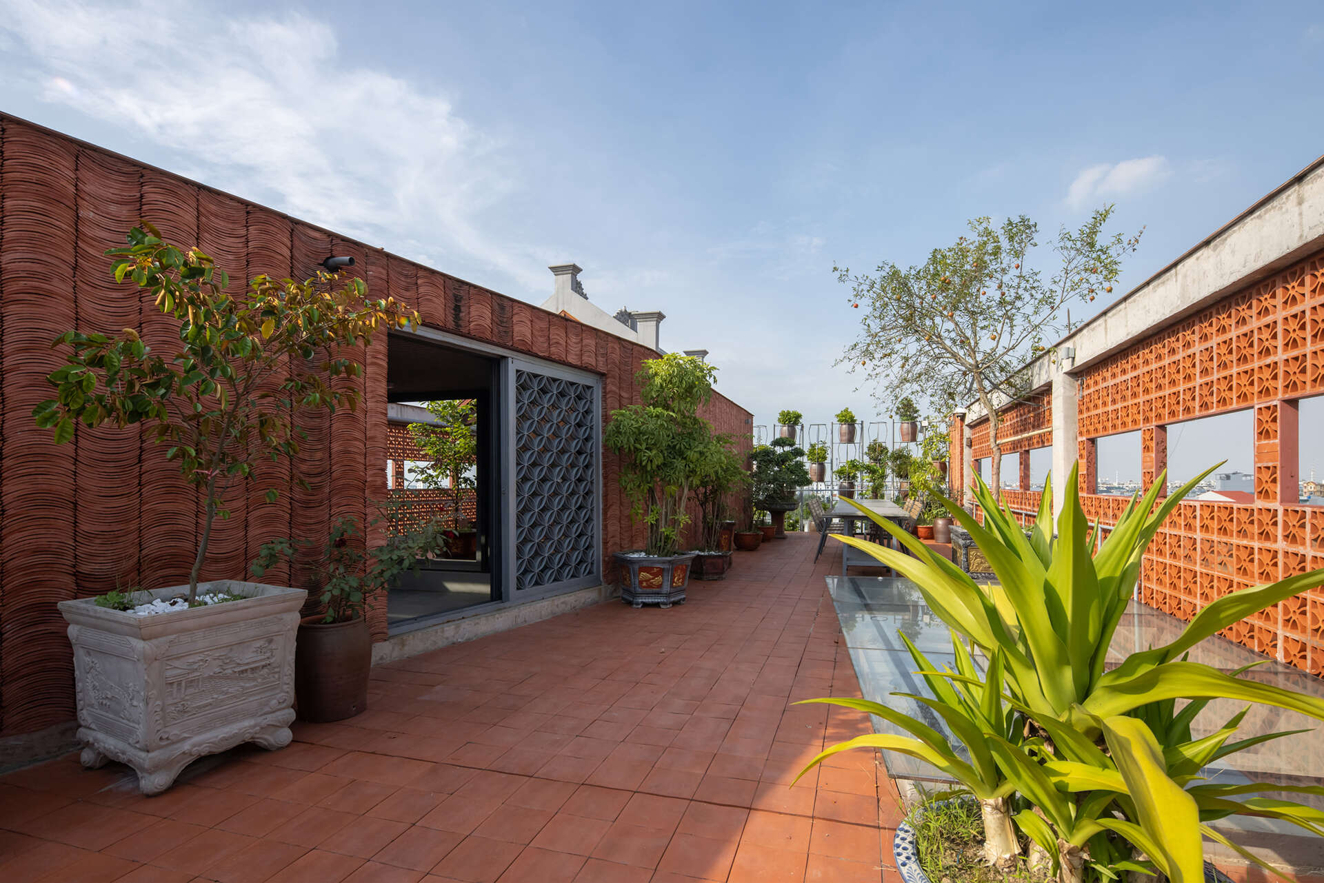 A shared rooftop space provides a place for gathering above the layered facade.