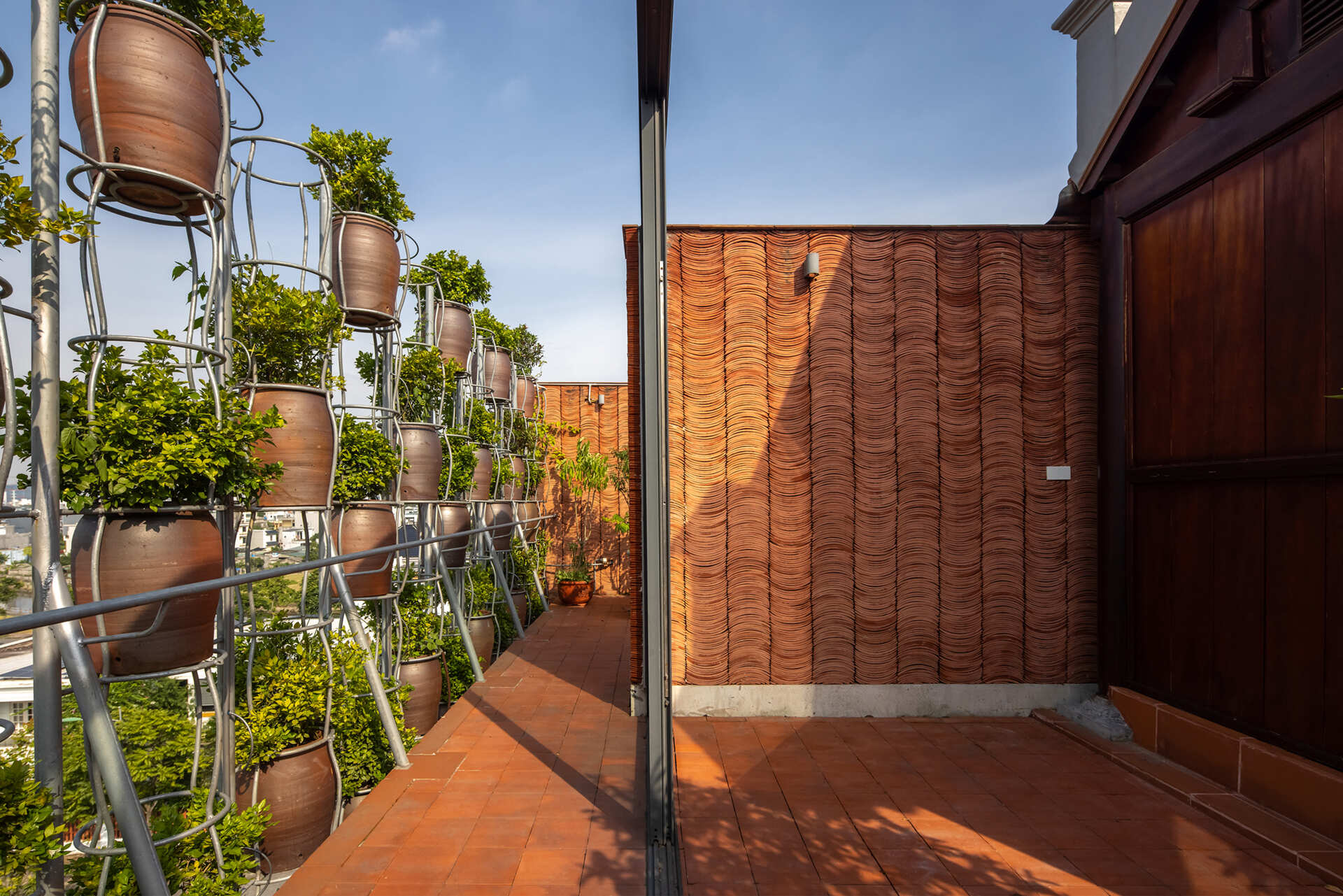 A shared rooftop space provides a place for gathering above the layered facade.