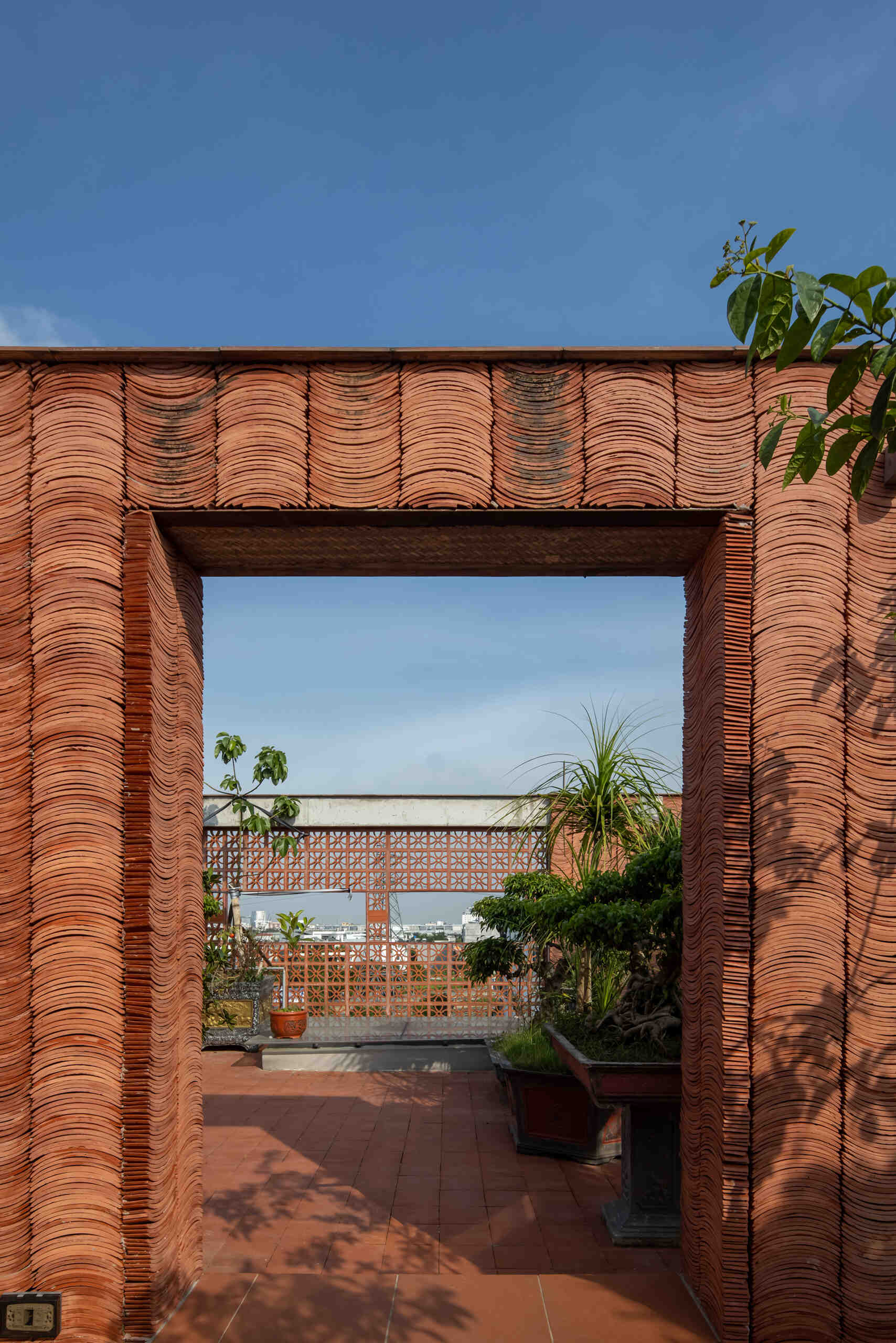 A shared rooftop space provides a place for gathering above the layered facade.