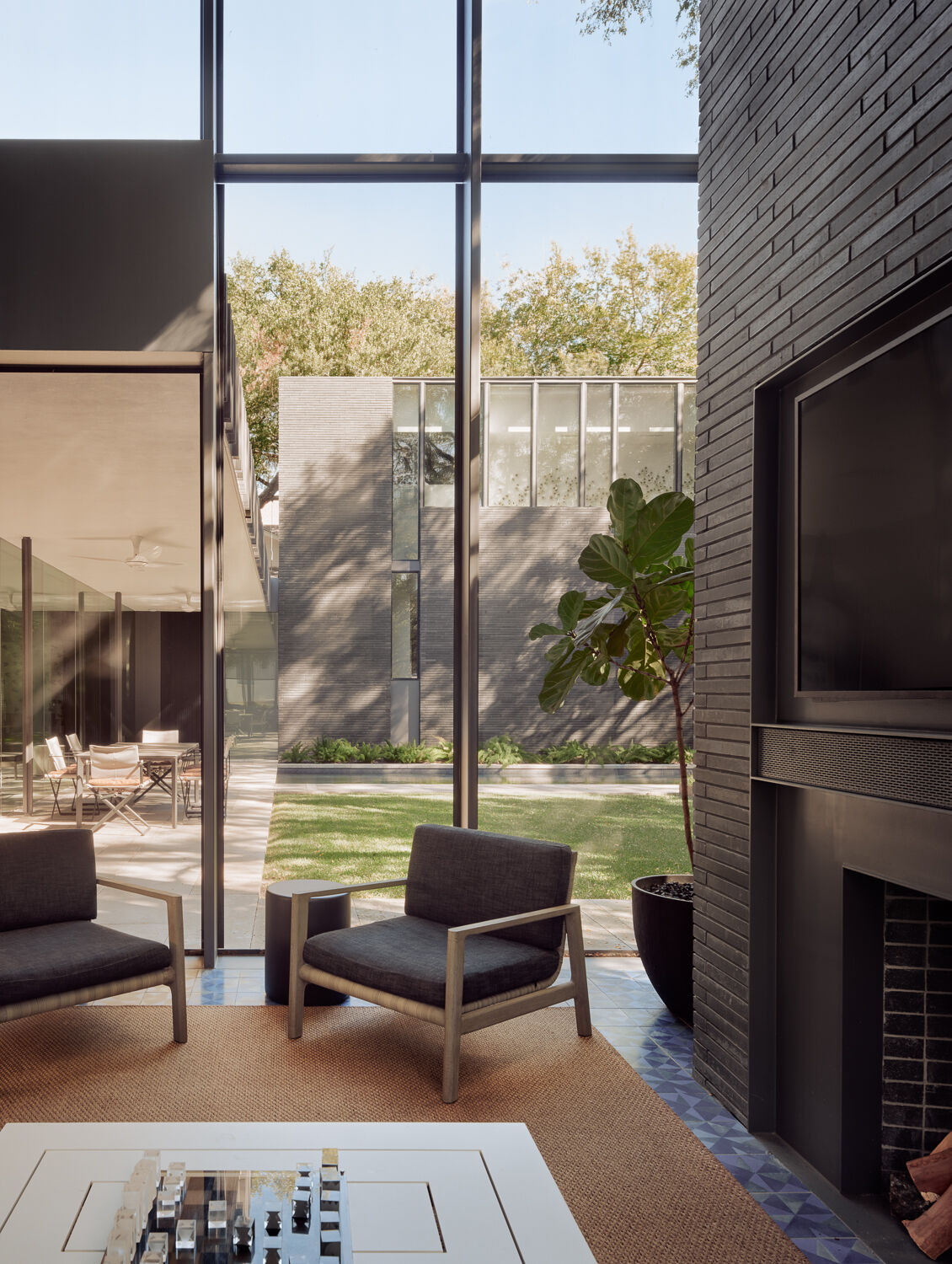 A dramatic two-story screened porch extends the living space outdoors, combining custom steel detailing, soaring proportions, and sheltered views of the surrounding landscape.
