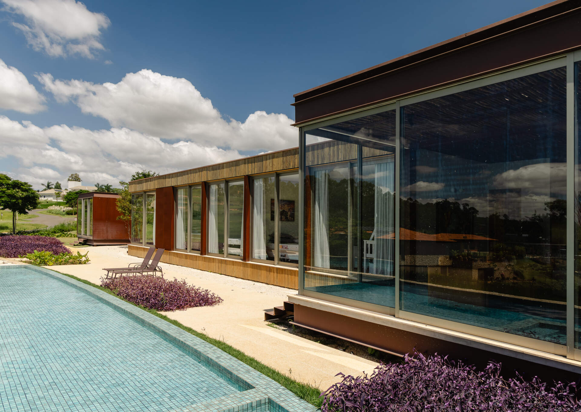 Built into a raised stone platform, the swimming pool terrace at Casa Themis combines panoramic countryside views with modern outdoor living and warm natural materials.