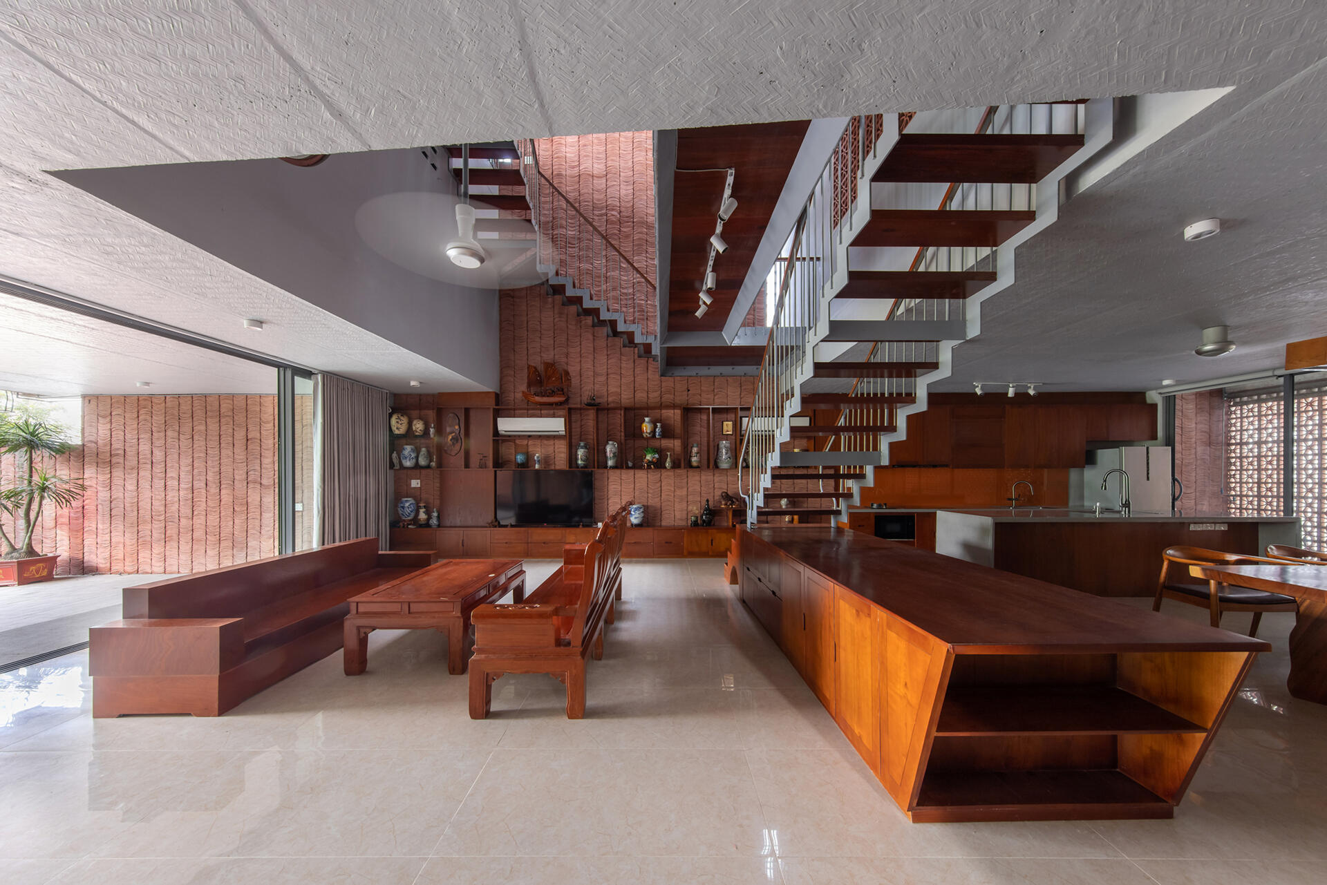 Concrete interiors are balanced with wood furniture, creating simple and adaptable living areas.