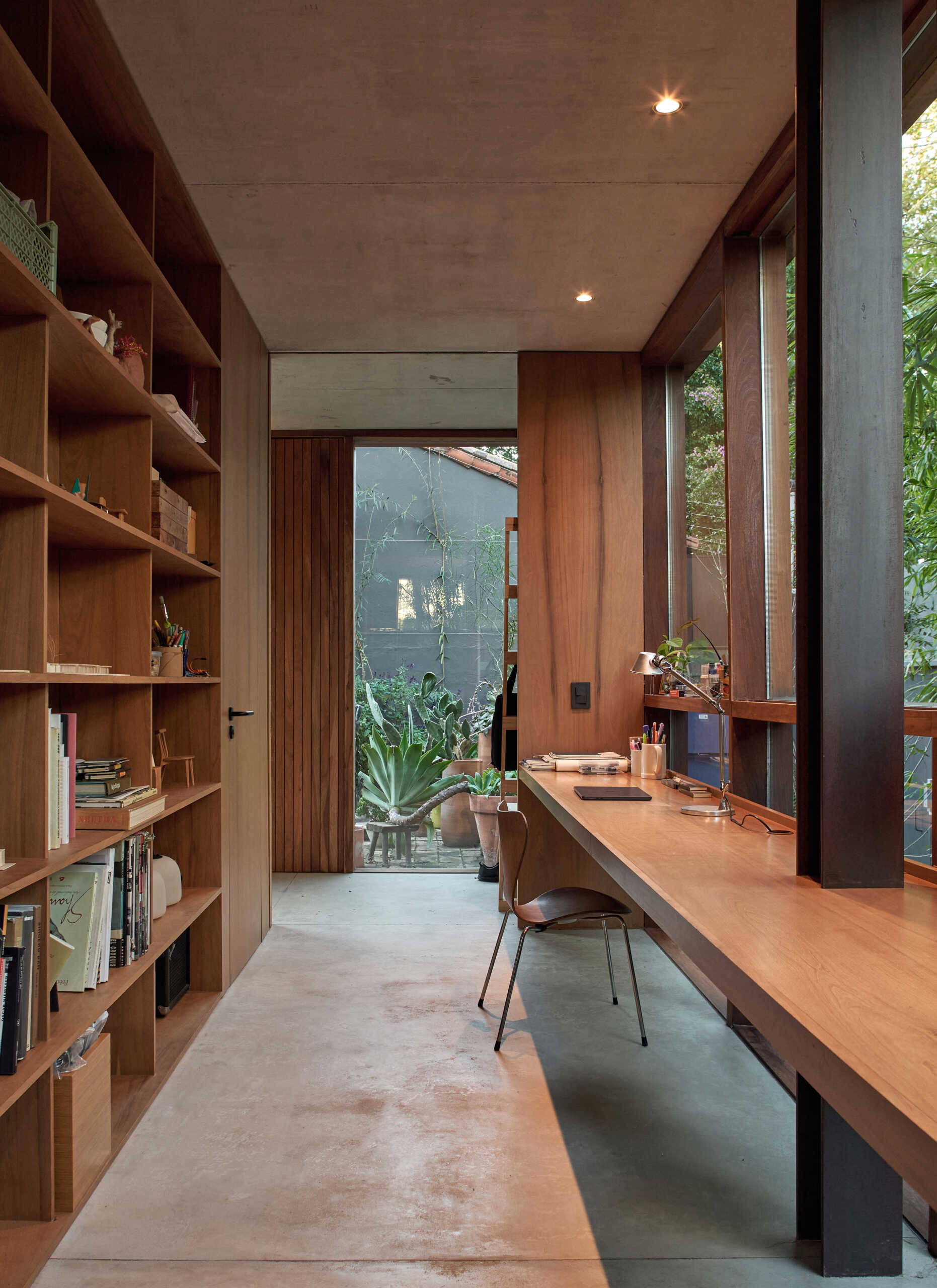 An open wood bookshelf and a built-in floating desk creates a simple, integrated home office.