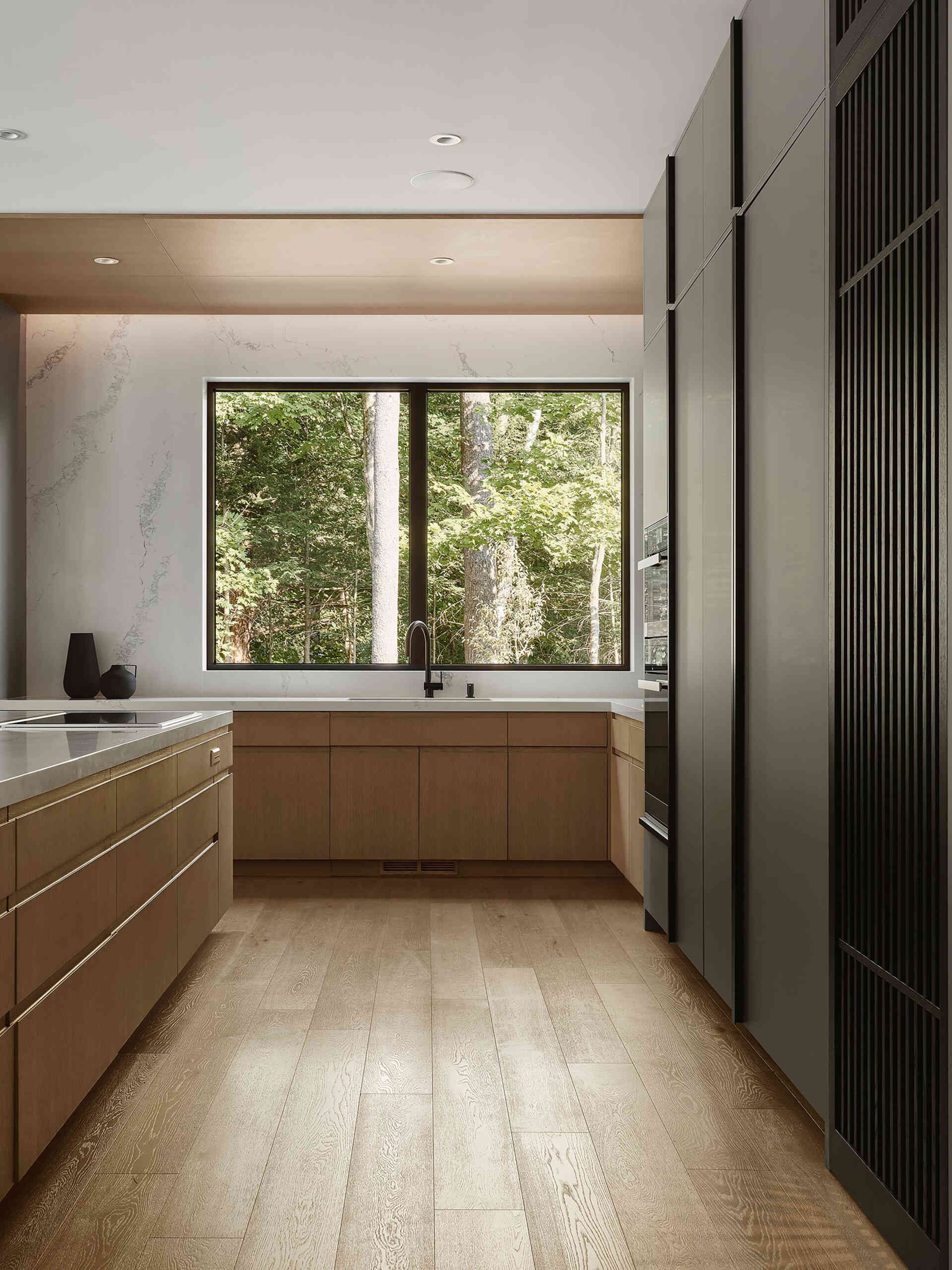 Pale grey cabinetry, natural wood, and quartz countertops give this modern kitchen a warm contemporary look with clean architectural styling.