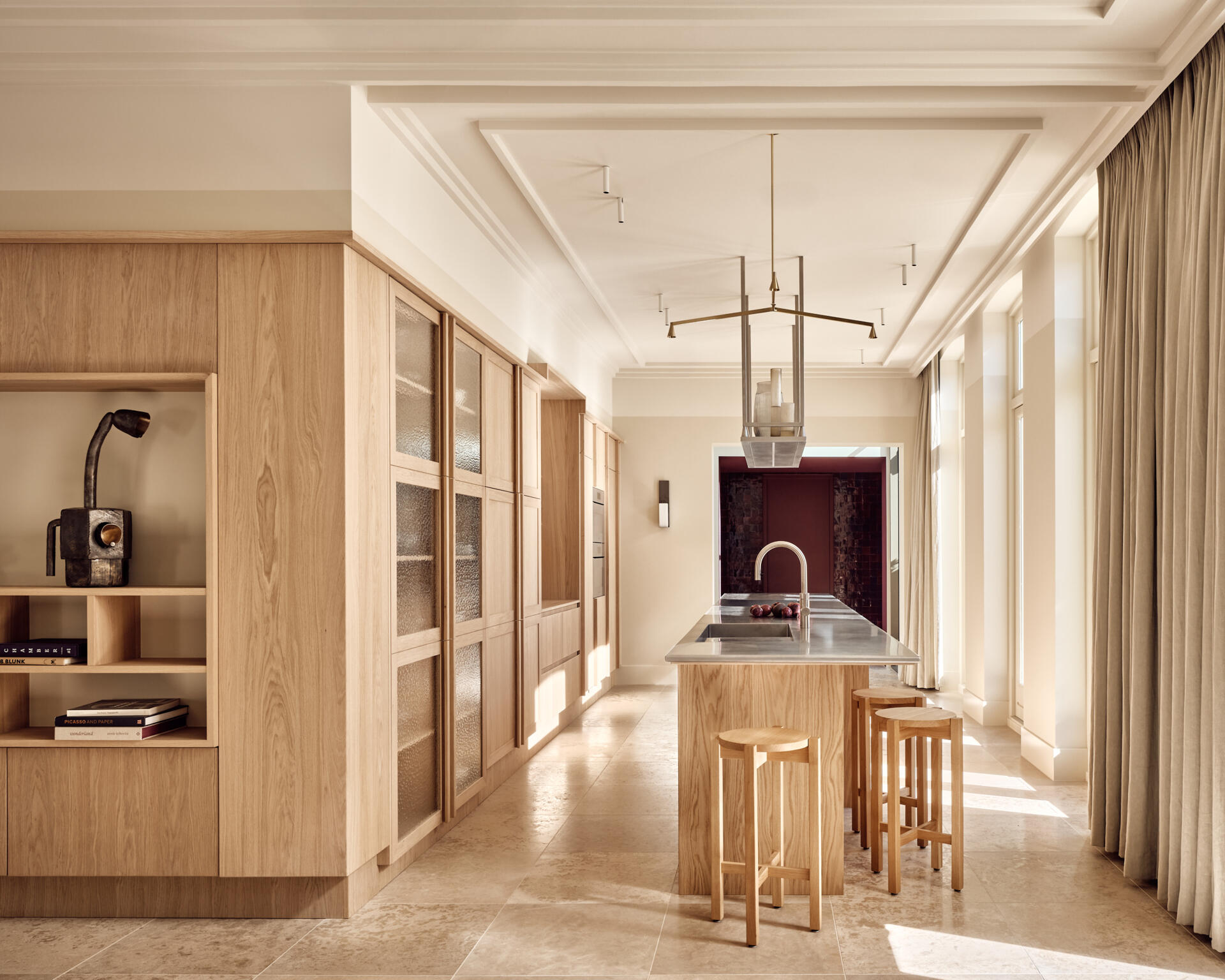 Warm wood cabinetry, textured glass, and stainless steel surfaces give this kitchen a perfect mix of comfort and modern edge.