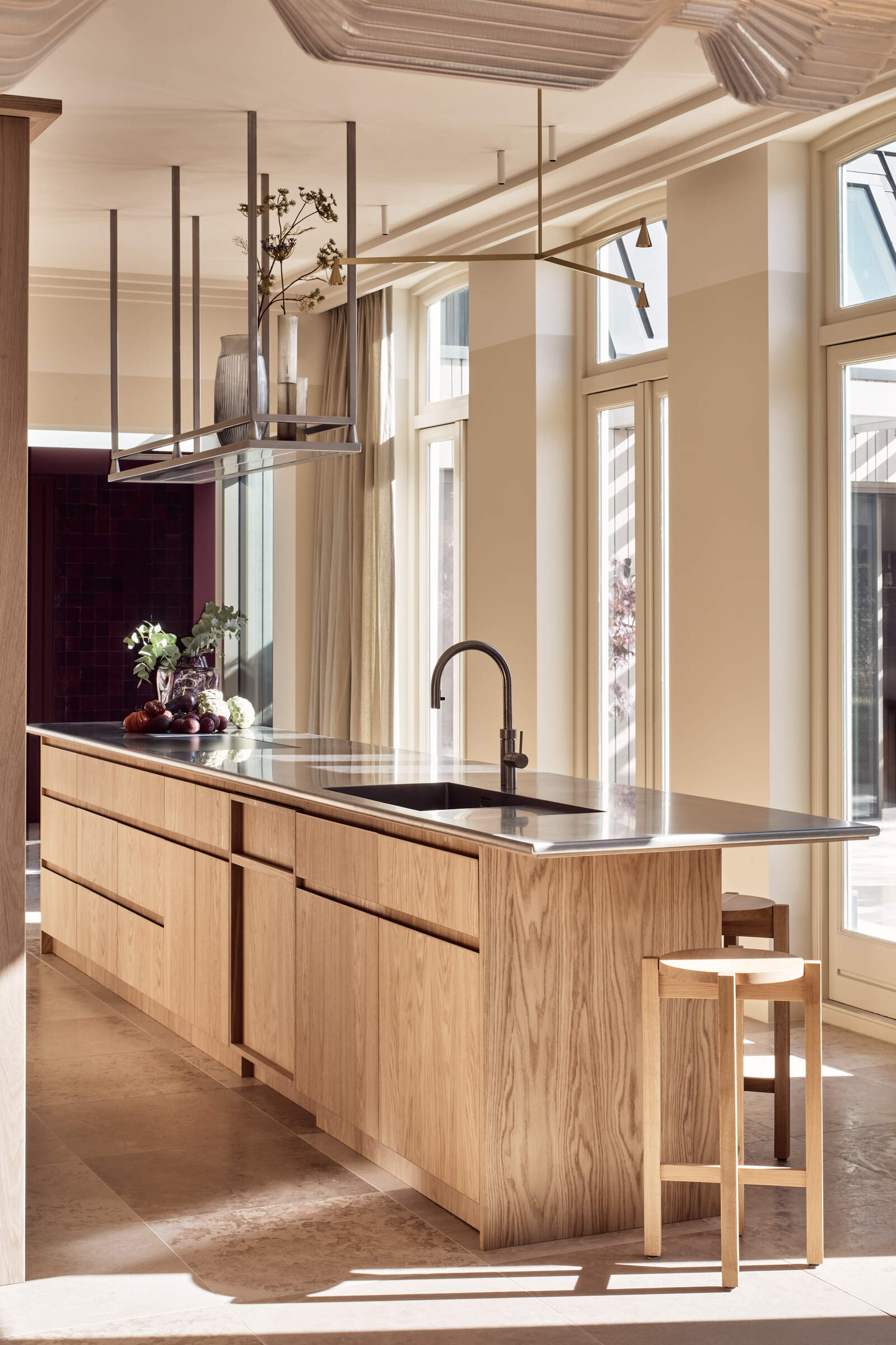 Warm wood cabinetry, textured glass, and stainless steel surfaces give this kitchen a perfect mix of comfort and modern edge.