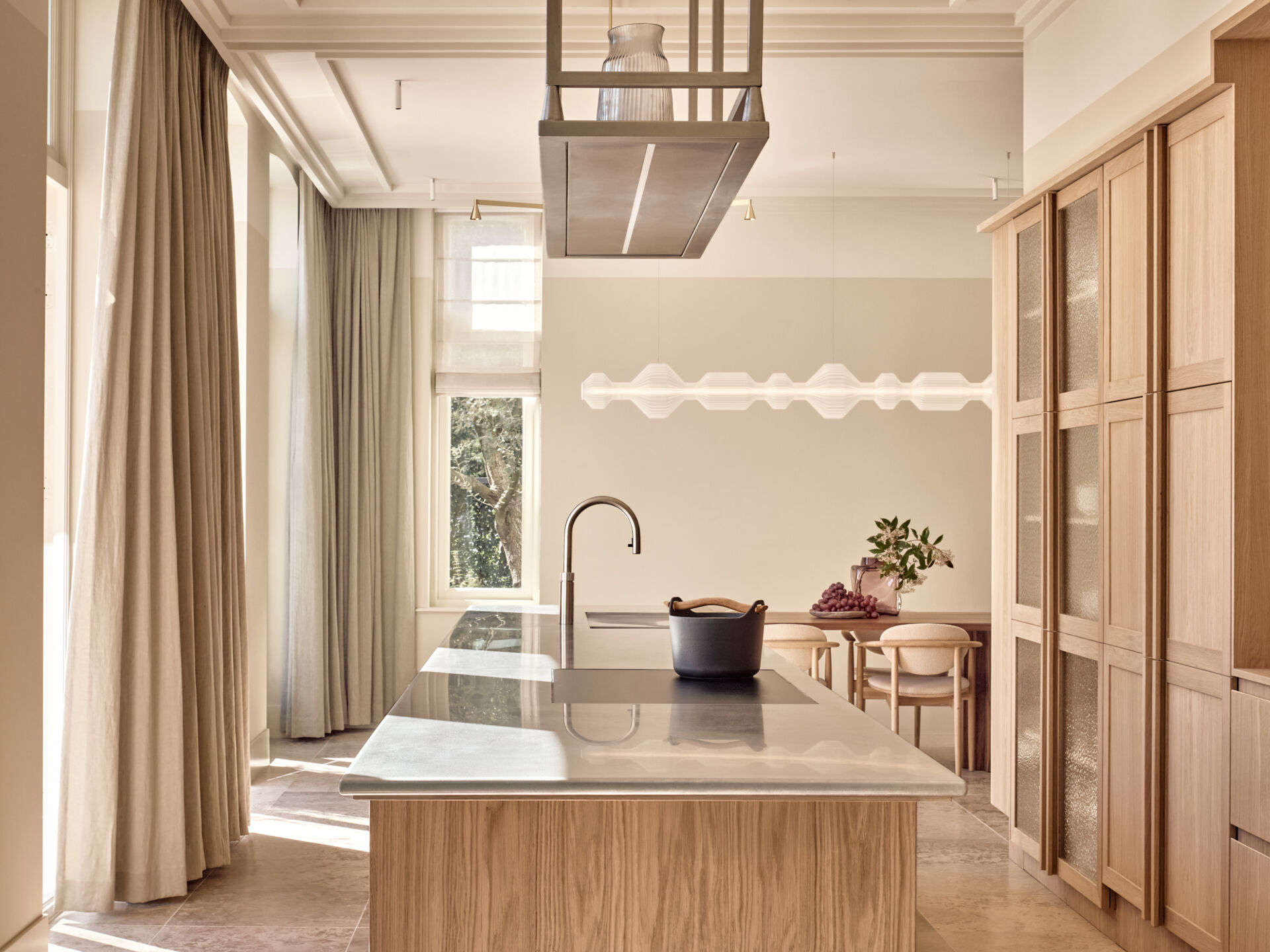 Warm wood cabinetry, textured glass, and stainless steel surfaces give this kitchen a perfect mix of comfort and modern edge.