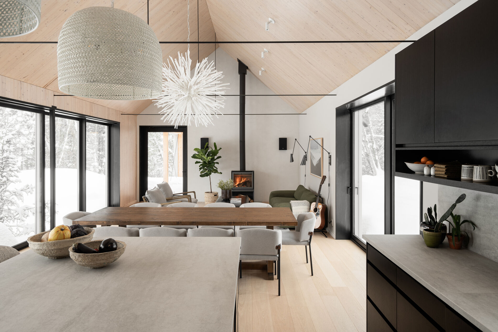 A modern mountain home with a great room that includes a living area, dining area, and kitchen.