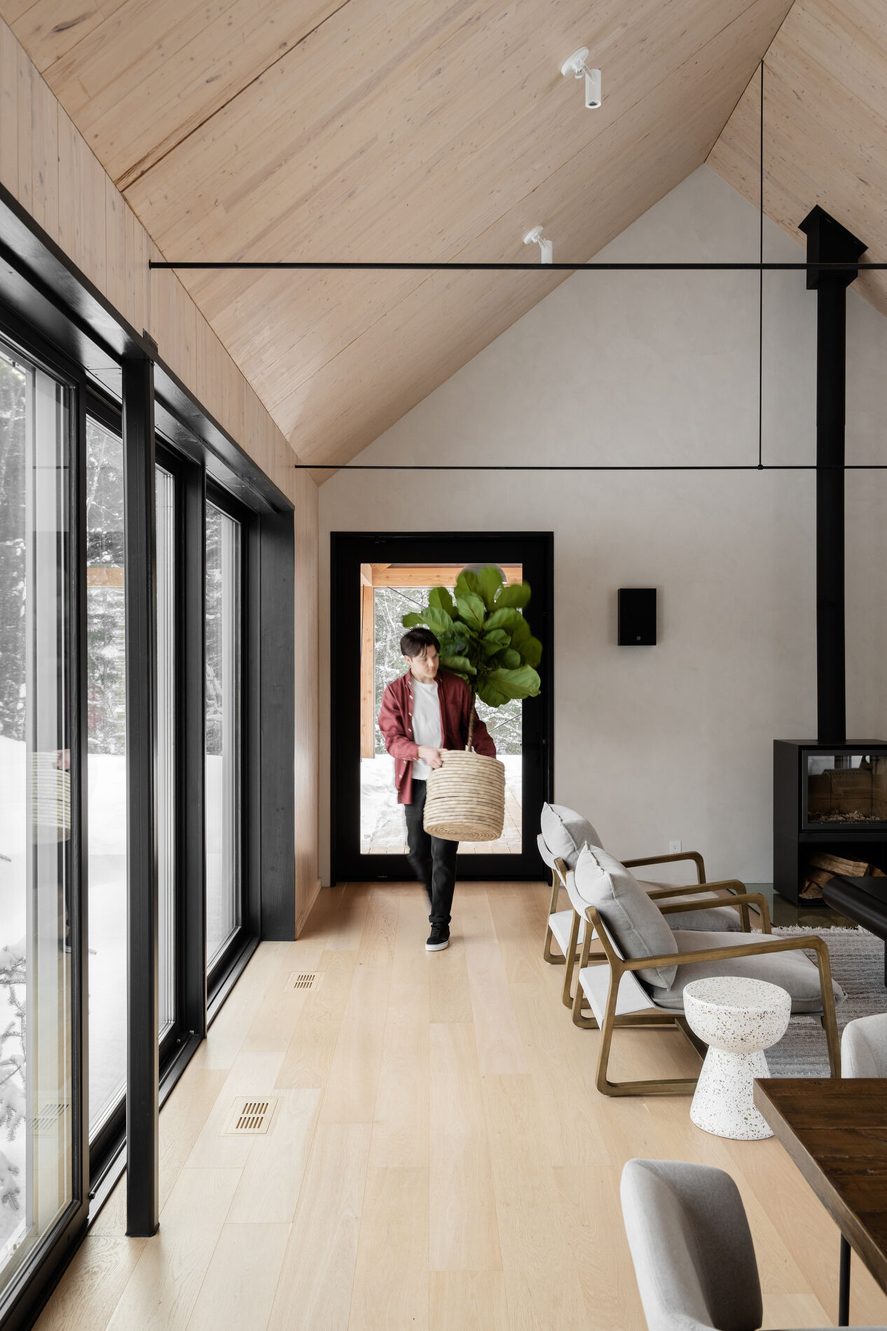 Positioned within one of the gabled volumes, the main living room benefits from both privacy and expansive views. The exposed timber structure defines the space, adding texture and warmth without relying on excessive finishes. 