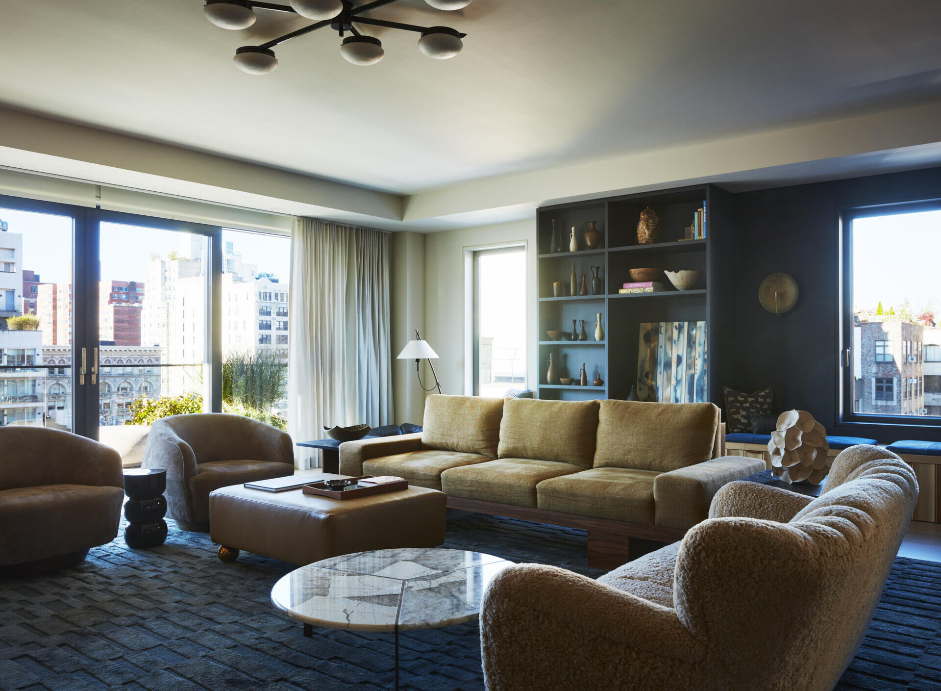 The living and dining area combines custom millwork, soft textures, and collected furniture pieces to make the open-plan layout feel welcoming. Hidden storage for more than 800 vinyl records and an integrated stereo system reflects the family’s love of music while keeping the room visually clean.