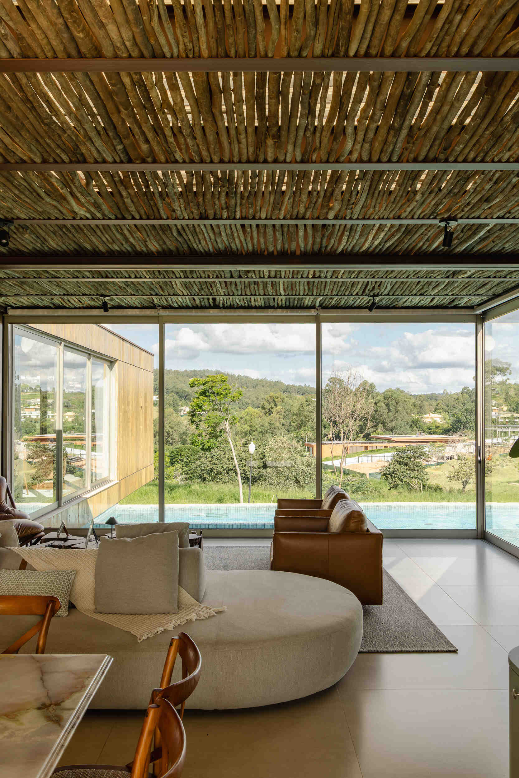 Floor-to-ceiling glass, open-plan interiors, and a floating cantilevered living room make the social spaces inside Casa Themis feel bright, modern, and connected to nature.