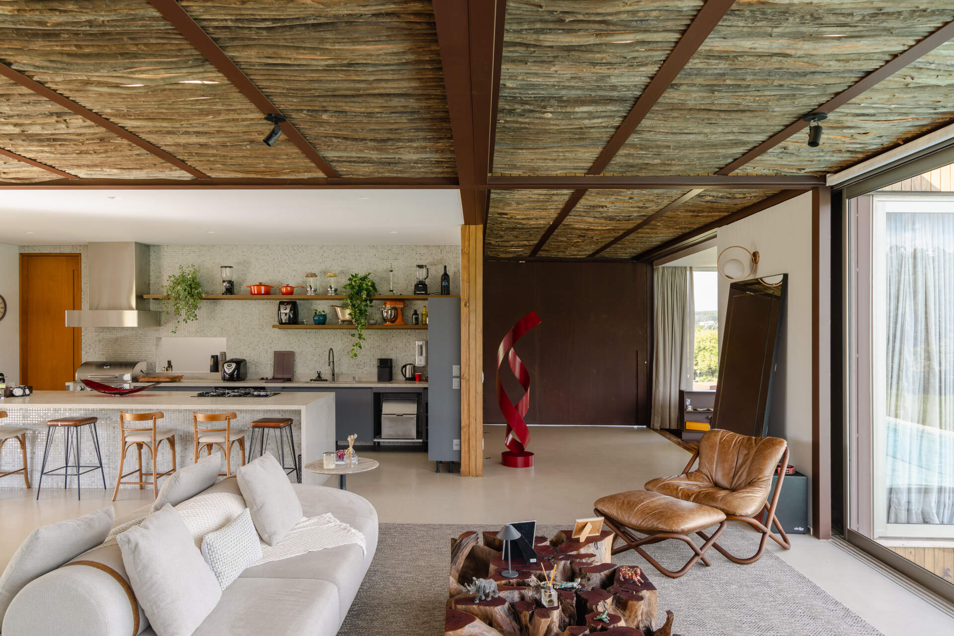 Casa Themis uses an L-shaped layout to connect dining spaces, lounges, and outdoor terraces, creating a home designed for entertaining and relaxed weekends.