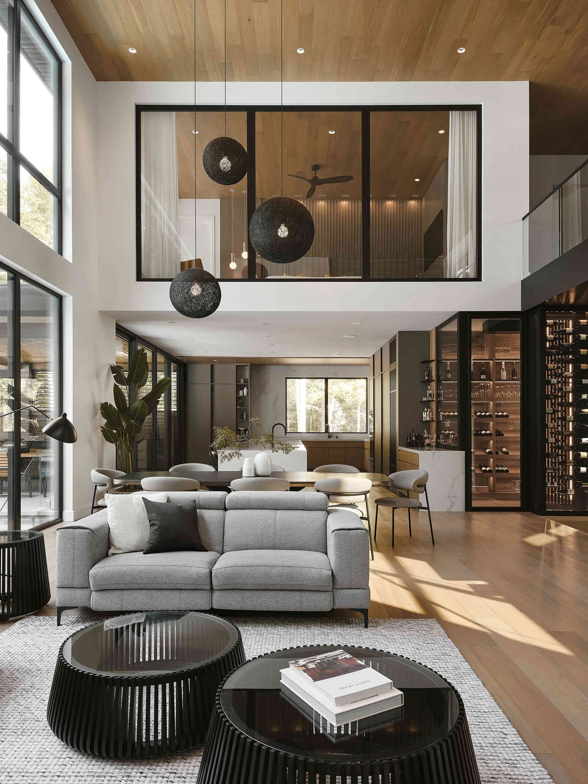 A modern living room with a double-height wood-lined ceiling, fireplace, and open floor plan.