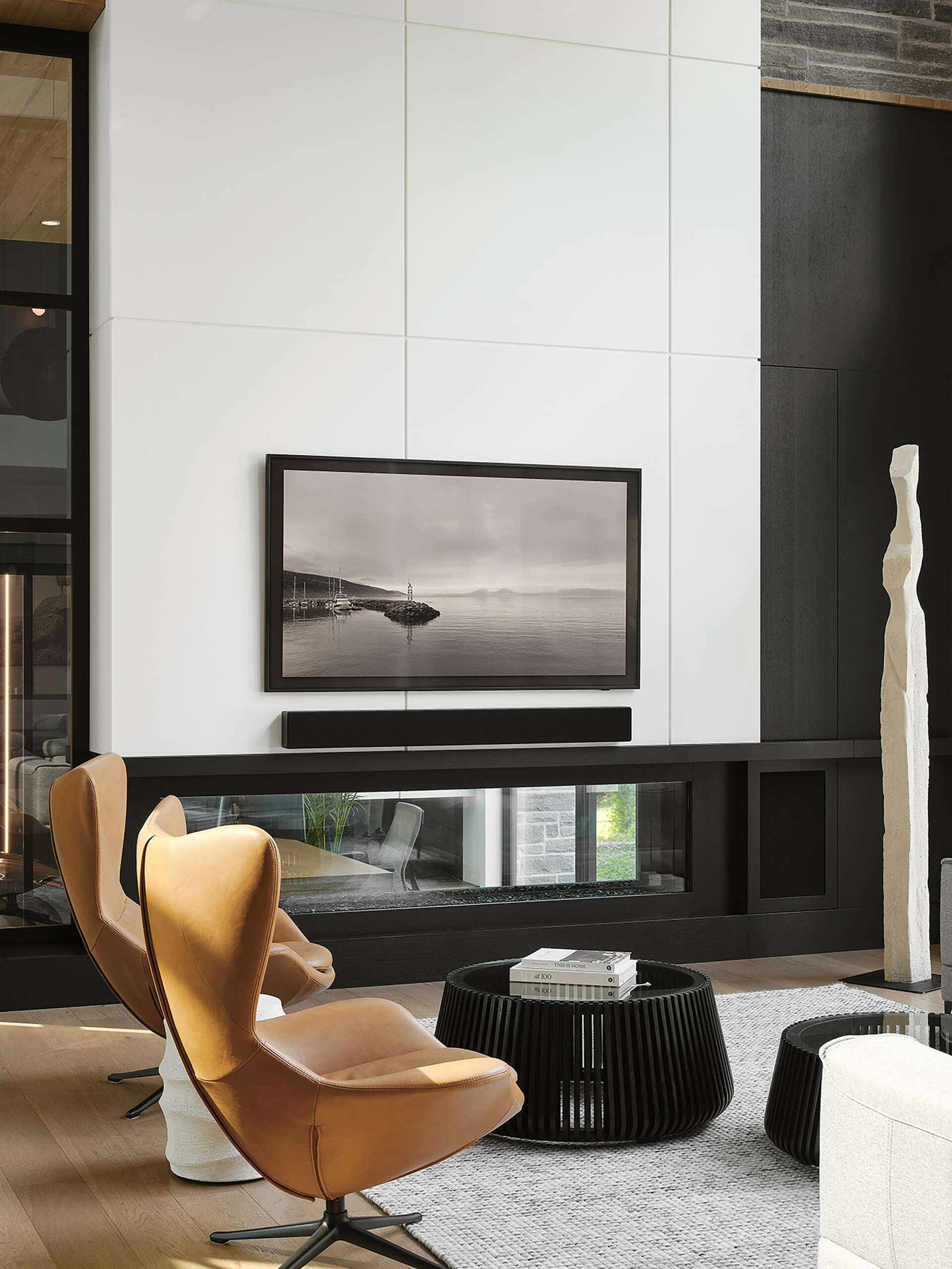 A modern living room with a double-height wood-lined ceiling, fireplace, and open floor plan.
