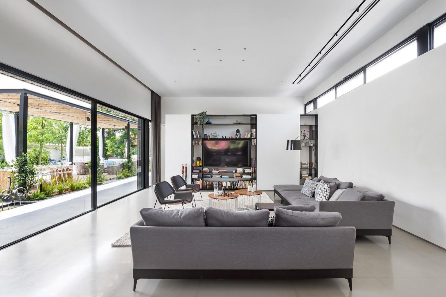 Large sliding glass doors connect this modern living room directly to the outdoor entertaining and pool areas.