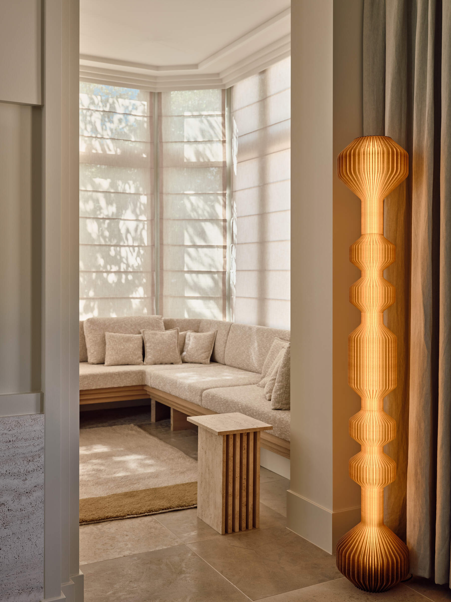 Warm walnut, textured glass, fireplaces, and custom seating make this riverside living room feel inviting, layered, and full of atmosphere.