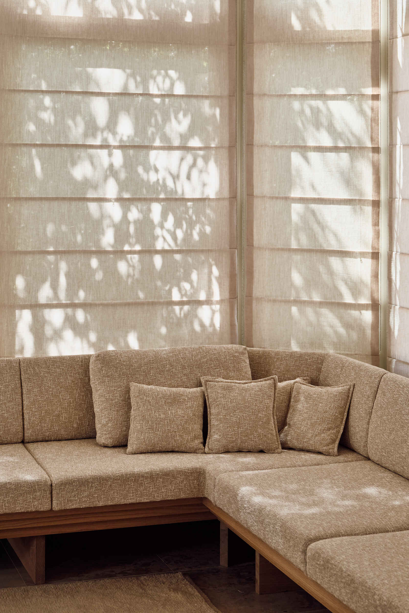 Warm walnut, textured glass, fireplaces, and custom seating make this riverside living room feel inviting, layered, and full of atmosphere.