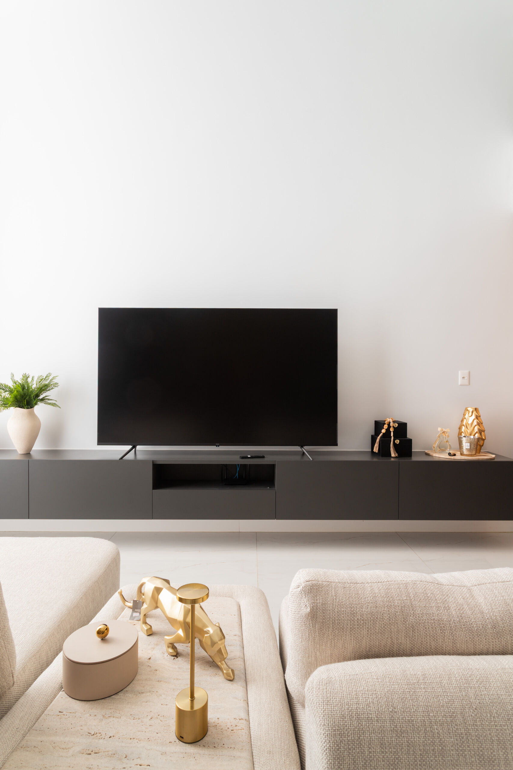 A dramatic double-height living room in Casa R|L combines exposed concrete, warm wood finishes, and sculptural structural elements in this contemporary Brazilian home.