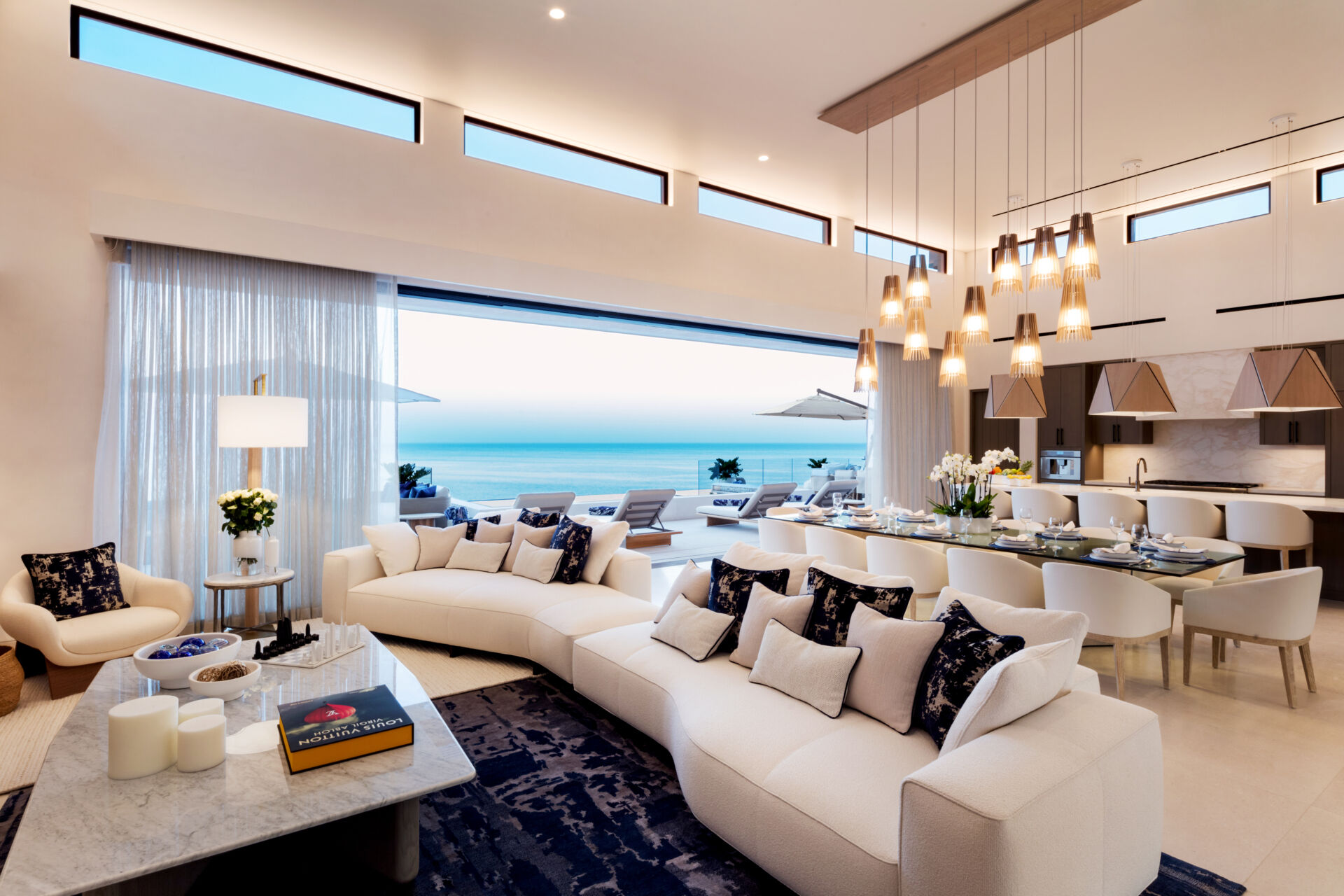The living room in this Los Cabos condo combines ocean views, layered woods, and relaxed seating designed for family gatherings.