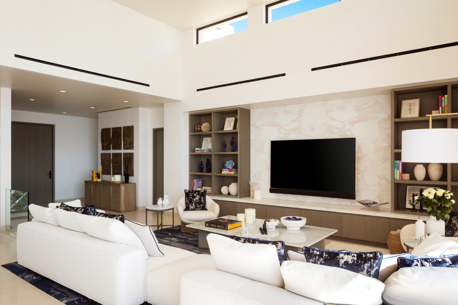 The living room in this Los Cabos condo combines ocean views, layered woods, and relaxed seating designed for family gatherings.