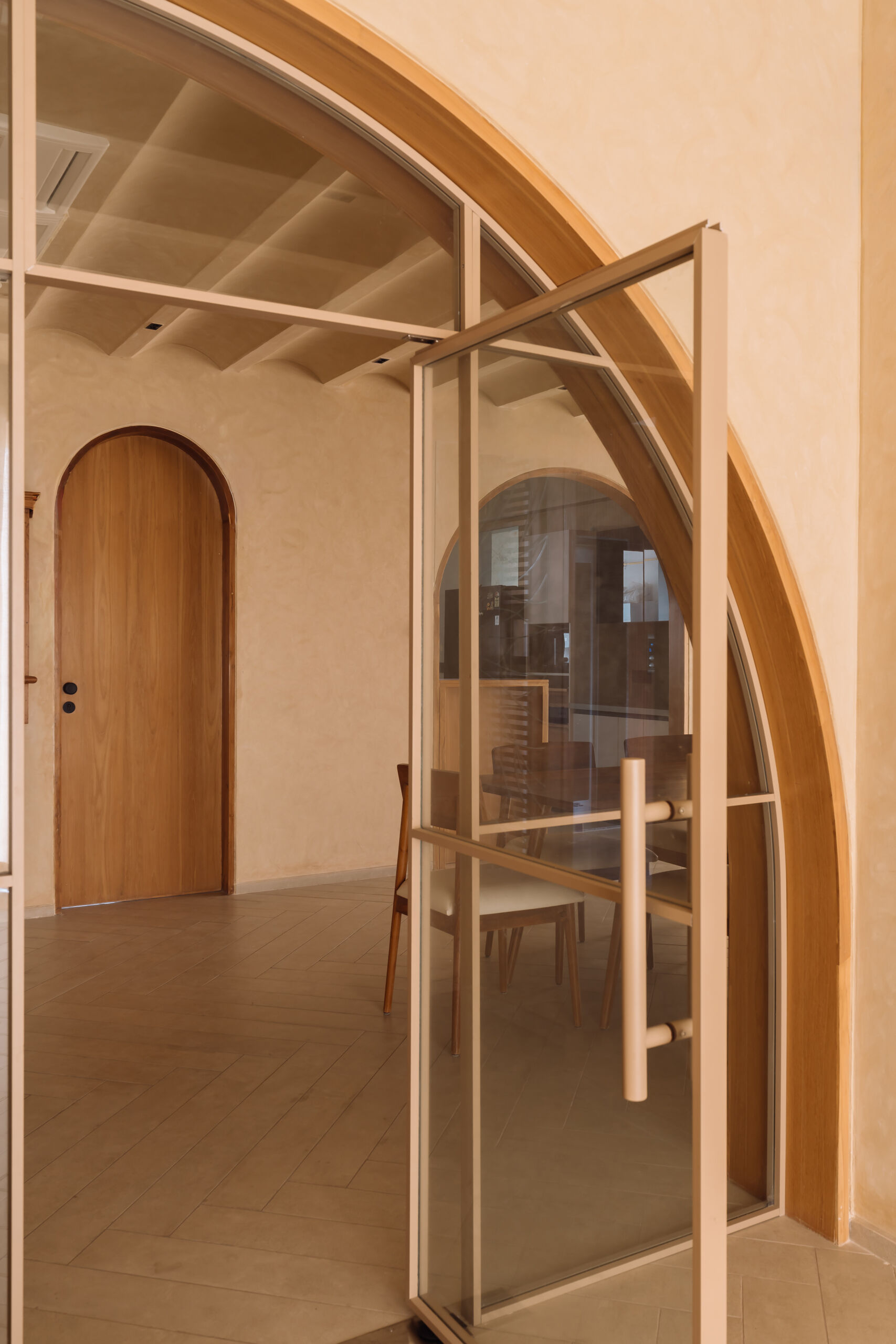 Exposed brick walls and sculptural arches give this Ahmedabad living room a warm minimalist atmosphere filled with texture, light, and soft architectural forms.