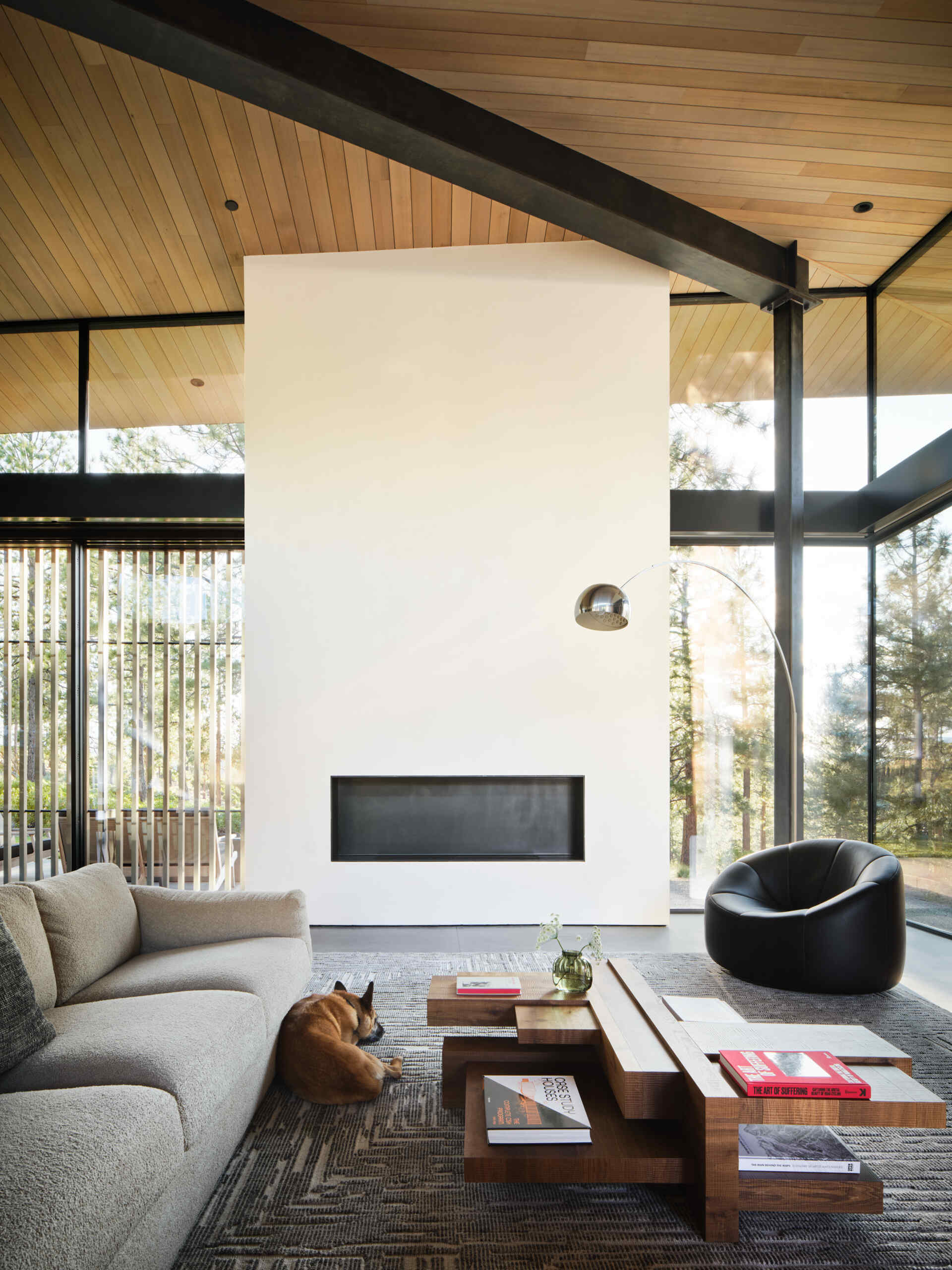 Clerestory windows, dramatic ceilings, and sliding glass walls make this modern living room feel completely immersed in the Oregon forest.