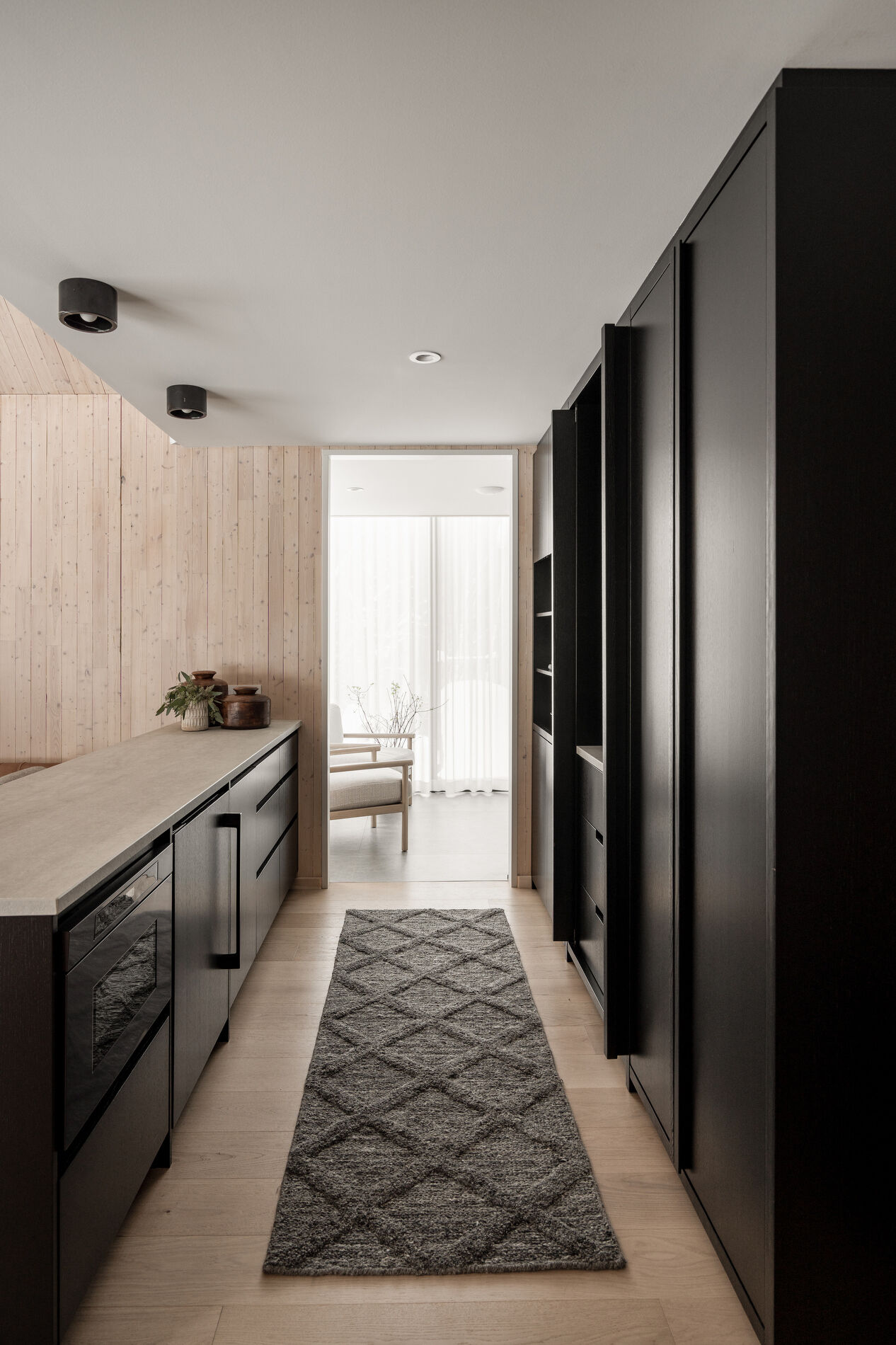 A modern kitchenette with black cabinets.