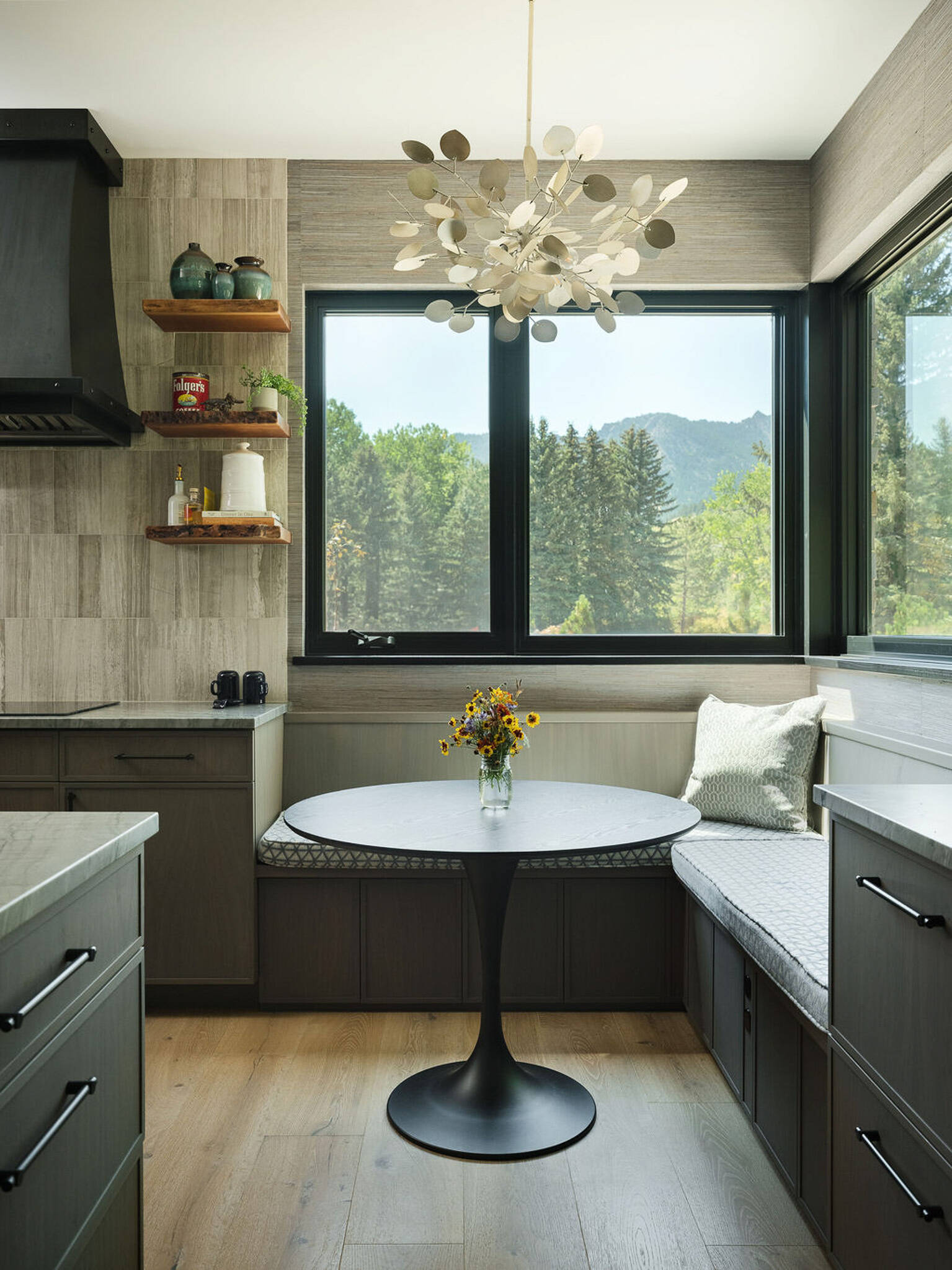 This modern kitchen pairs soft natural textures with a cozy built-in breakfast corner overlooking the Colorado landscape.