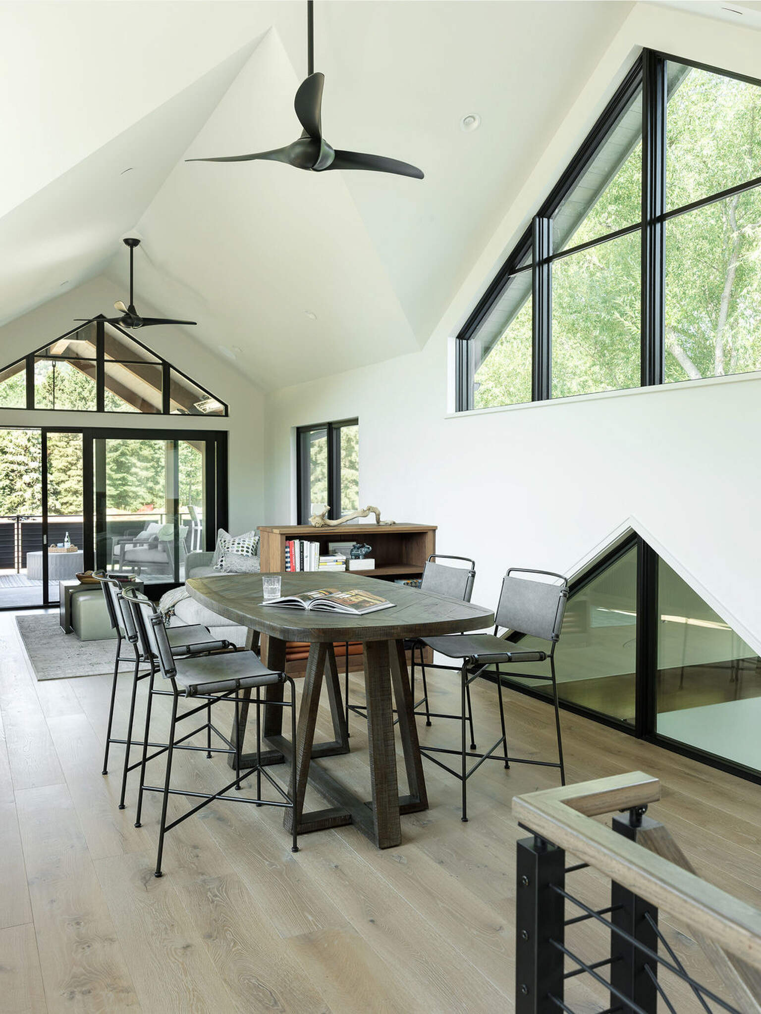 This sunlit upper-level living room uses interior glazing and mountain views to create a bright modern retreat.