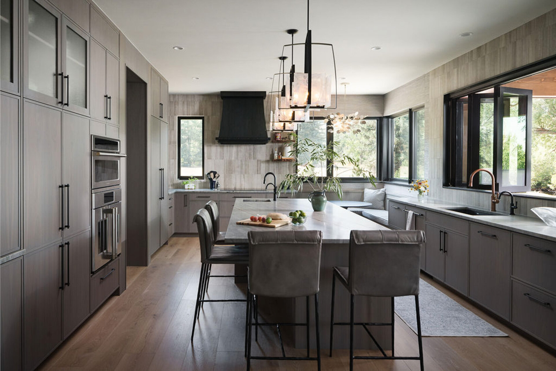 This modern kitchen pairs soft natural textures with a cozy built-in breakfast corner overlooking the Colorado landscape.