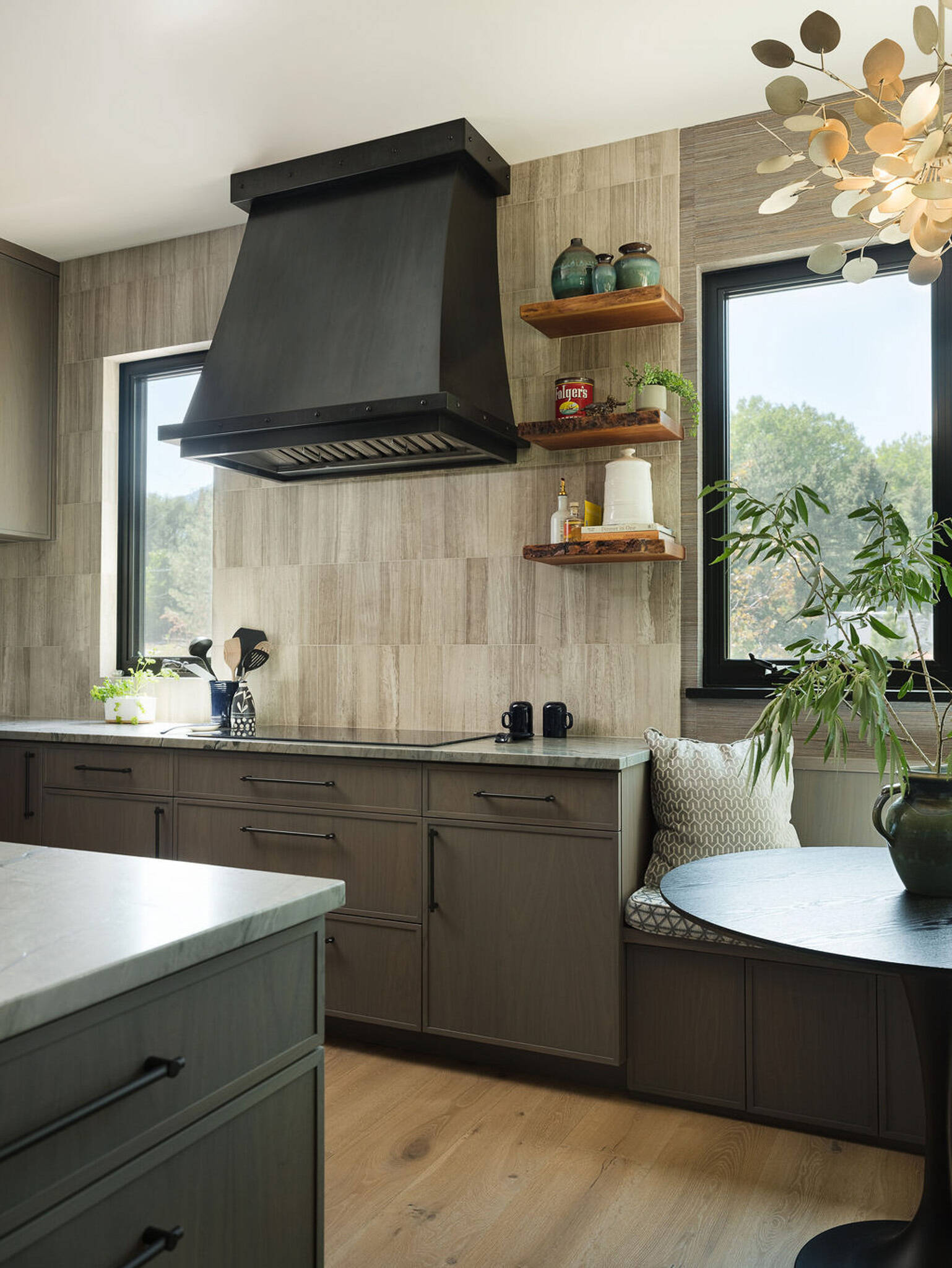 This modern kitchen pairs soft natural textures with a cozy built-in breakfast corner overlooking the Colorado landscape.